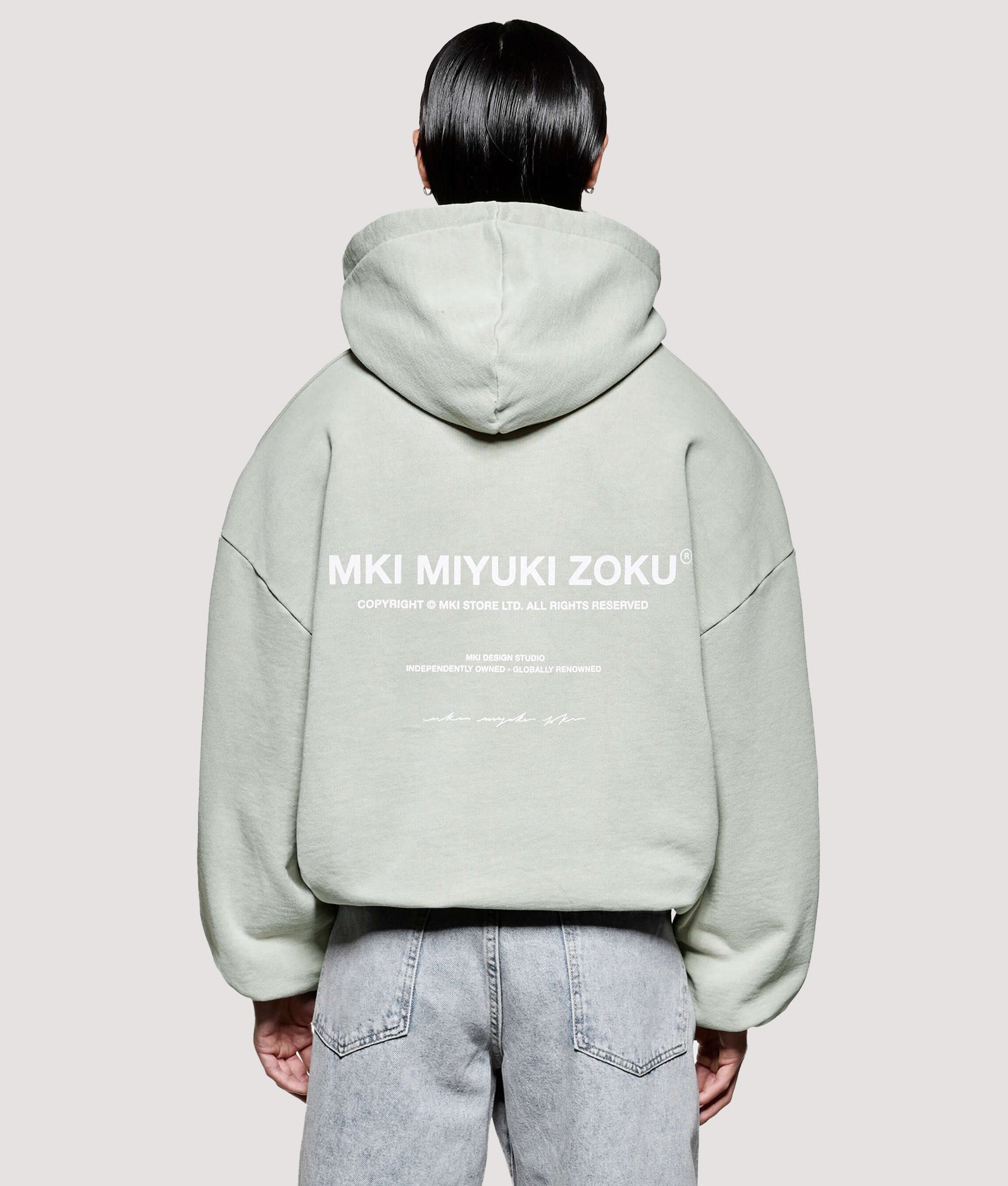 MKI MIYUKI ZOKU Box Fit Design Studio Hoodie in Pigment Cement at EQVVS Menswear. Model back shot.
