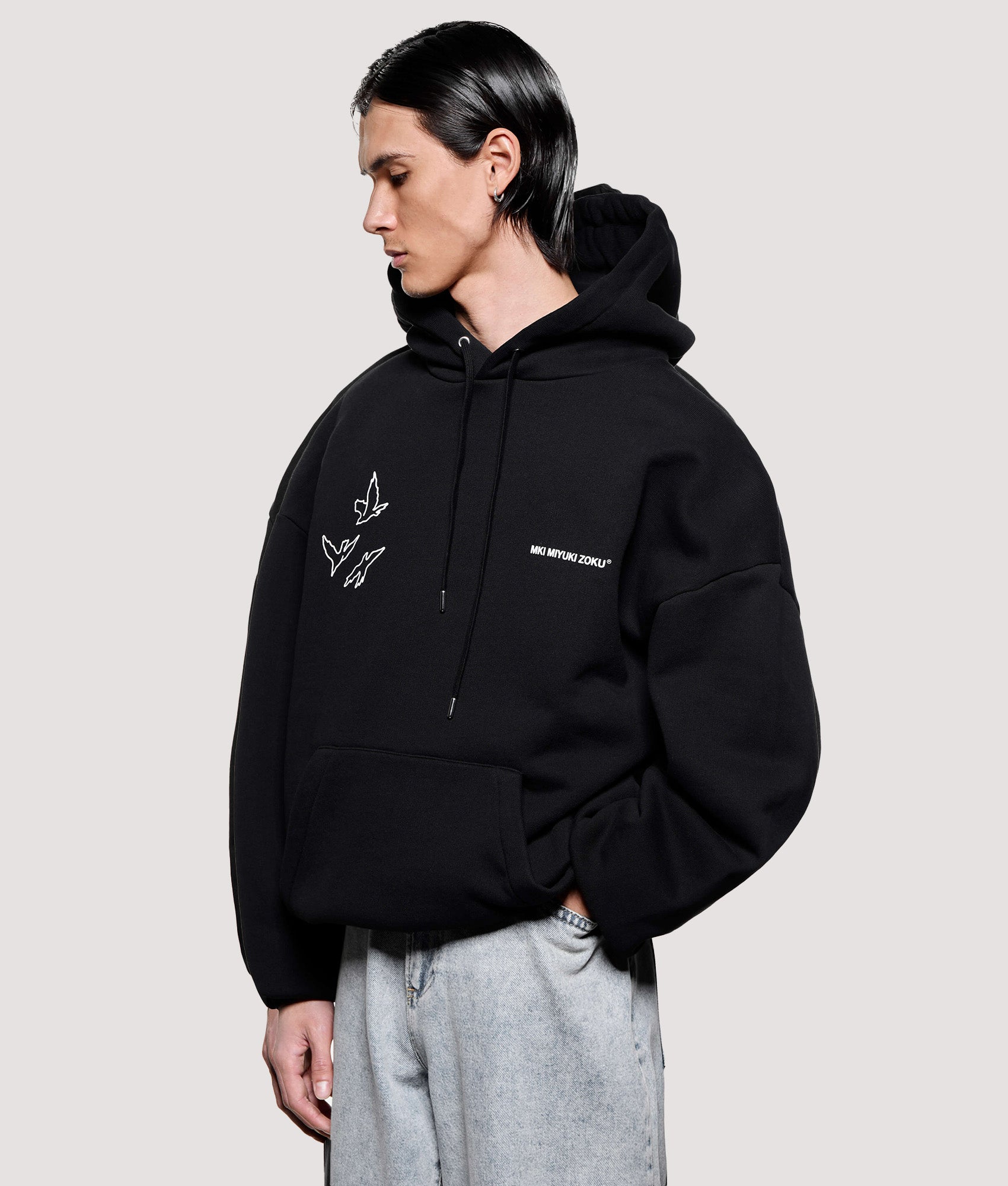 MKI MIYUKI ZOKU Box Fit Flight Hoodie in Black at EQVVS Menswear. Angled model front shot.