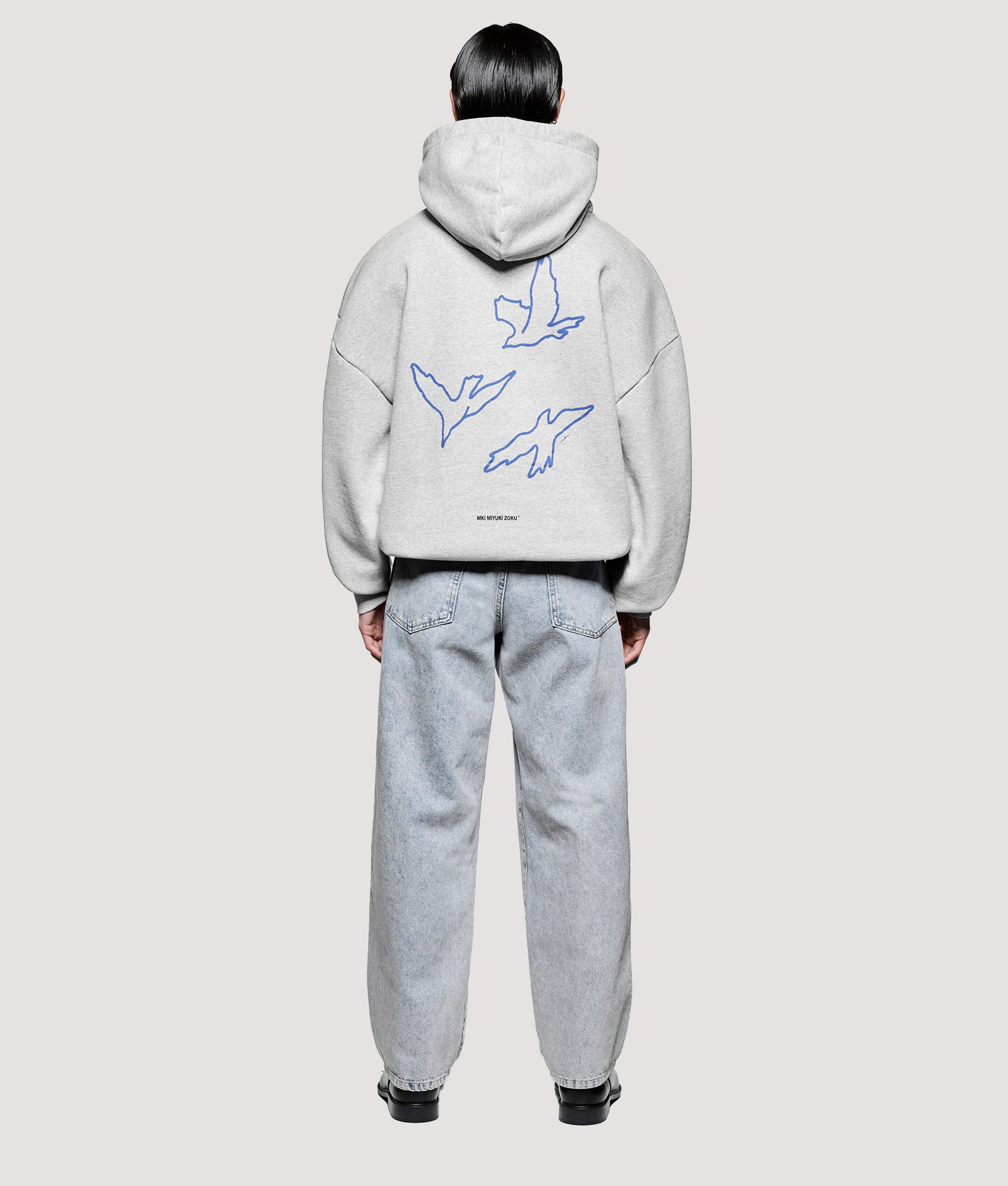 MKI MIYUKI ZOKU Box Fit Flight Hoodie in Grey at EQVVS Menswear. Model back shot.