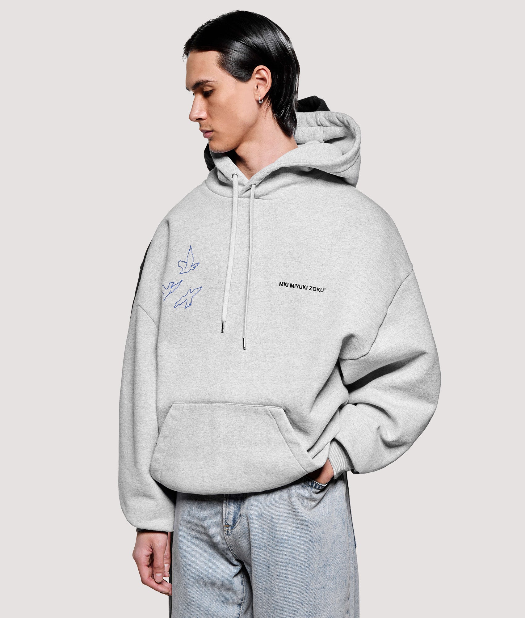 MKI MIYUKI ZOKU Box Fit Flight Hoodie in Grey at EQVVS Menswear. Angled front shot.