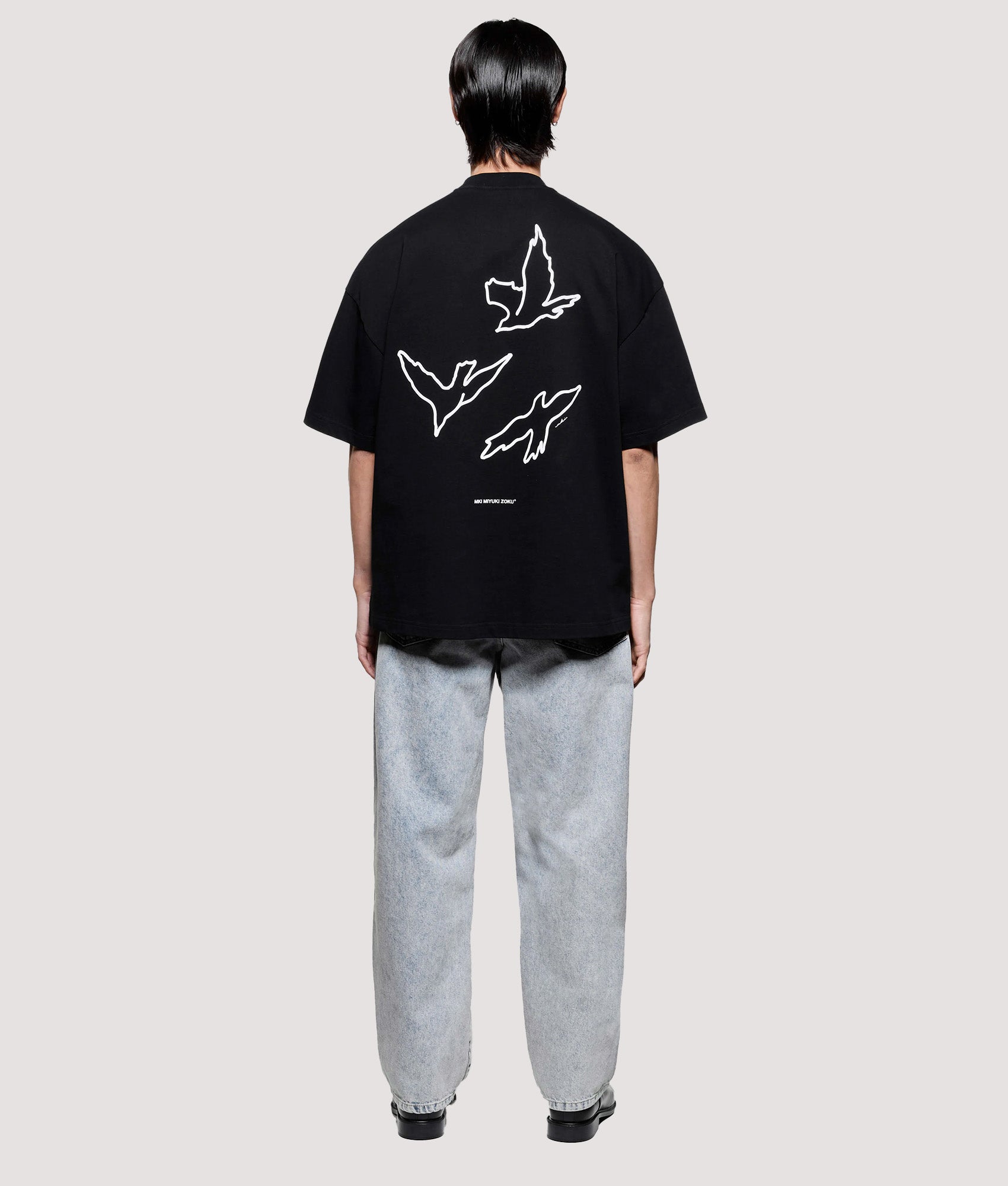 MKI MIYUKI ZOKU Box Fit Flight T-Shirt in Black at EQVVS Menswear. Model back shot.