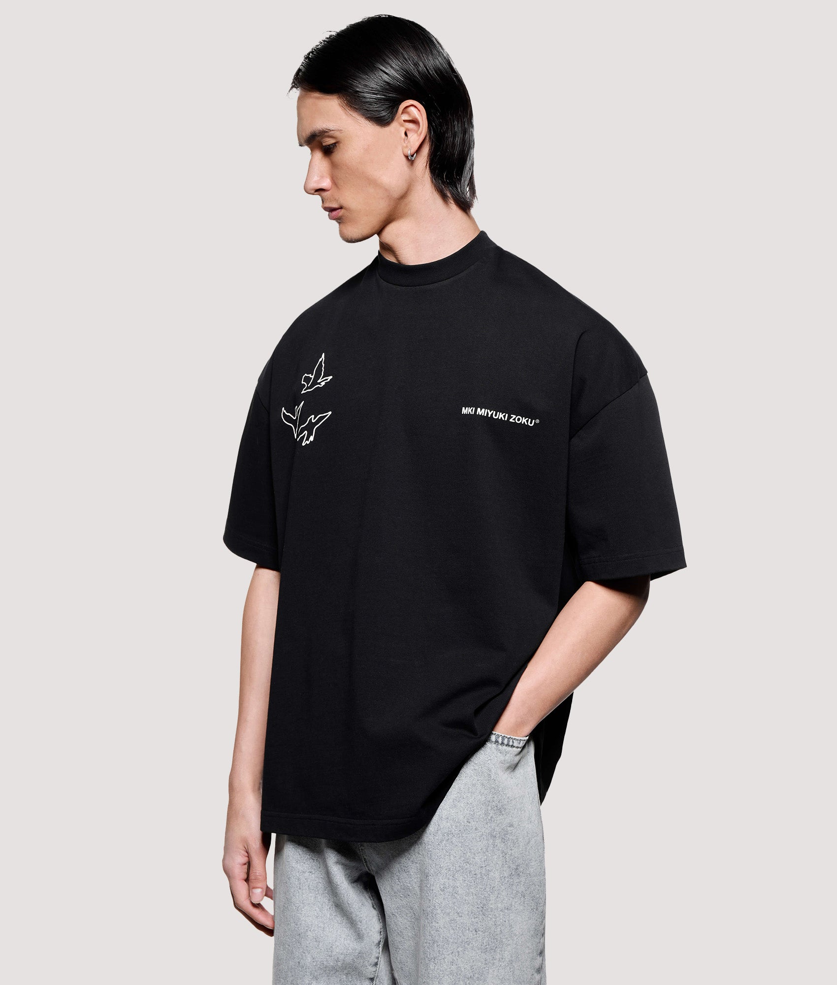 MKI MIYUKI ZOKU Box Fit Flight T-Shirt in Black at EQVVS Menswear. Angled model front shot.