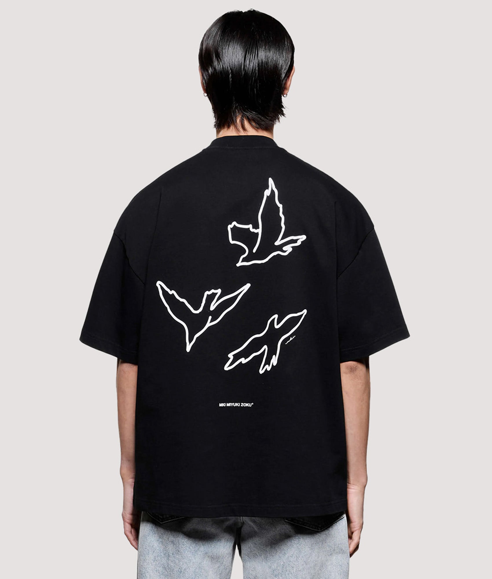 MKI MIYUKI ZOKU Box Fit Flight T-Shirt in Black at EQVVS Menswear. Angled model front shot.