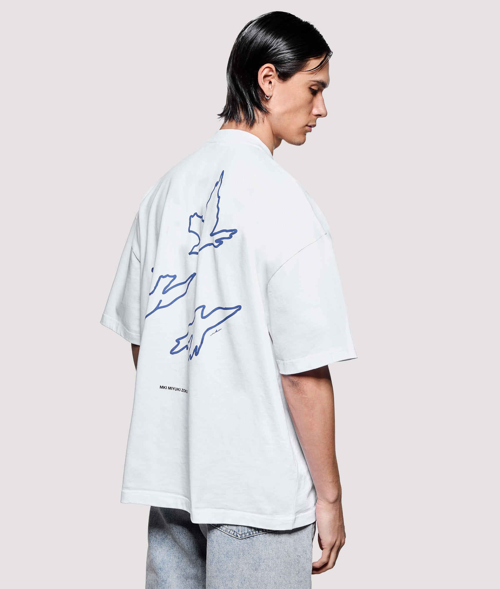 MKI MIYUKI ZOKU Box Fit Flight T-Shirt in White at EQVVS Menswear. Angled model front shot.