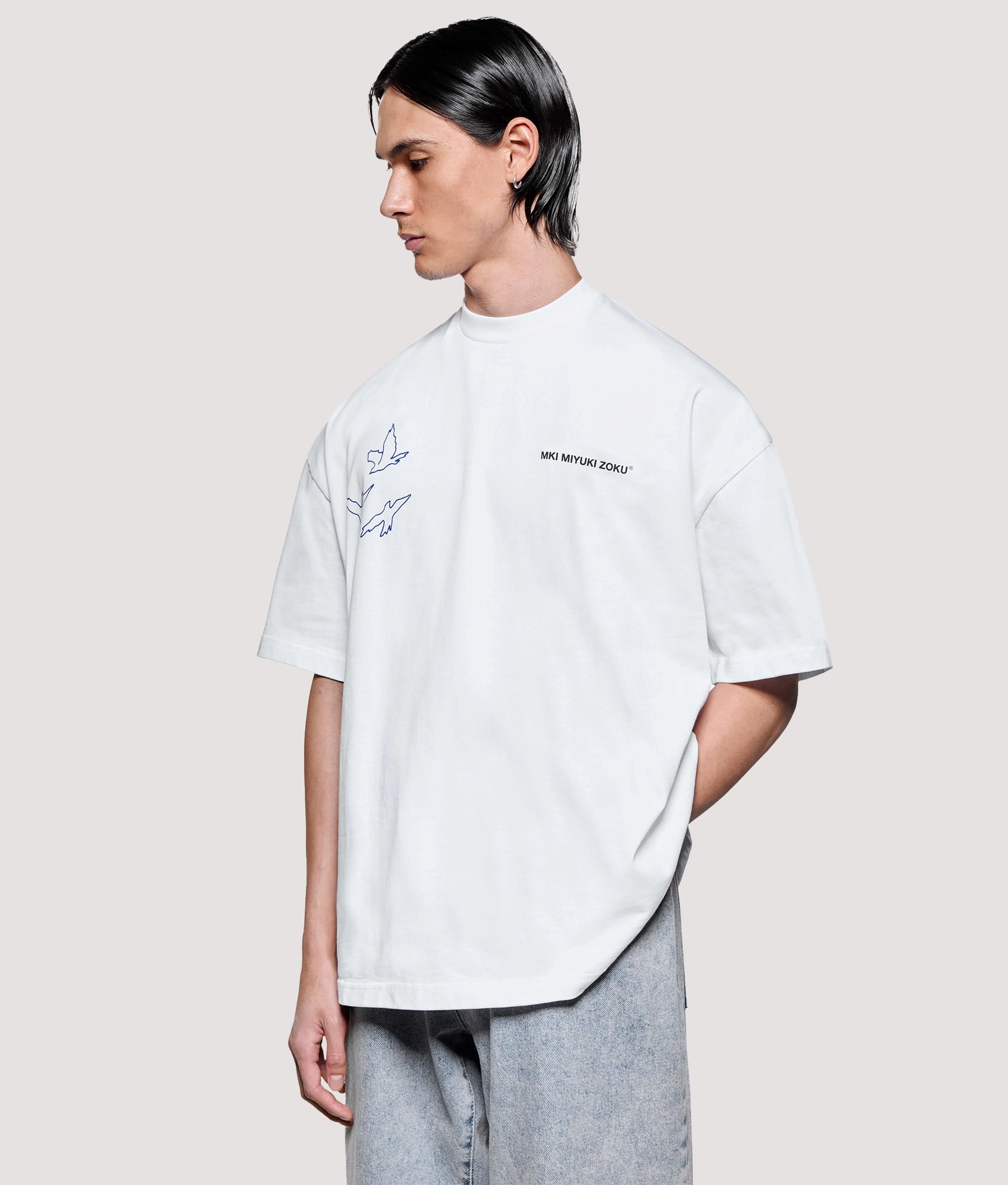 MKI MIYUKI ZOKU Box Fit Flight T-Shirt in White at EQVVS Menswear. Angled model front shot.