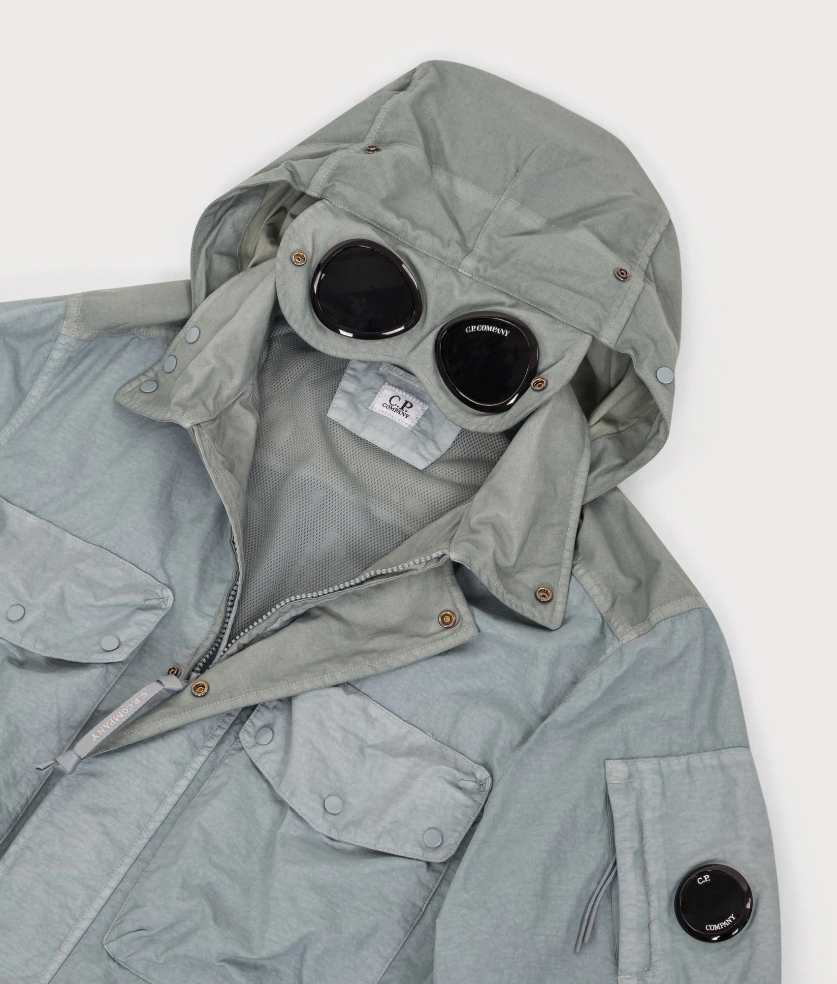 C.P. Company Flatt Nylon Mixed Goggle Overshirt in Silver blue at EQVVS Menswear. Hood shot.