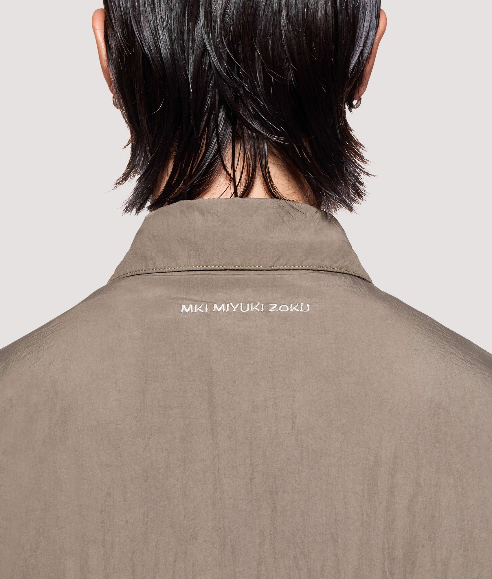 MKI MIYUKI ZOKU Box Fit Garment Dye Overshirt in Deep Khaki at EQVVS Menswear. Back detail shot.