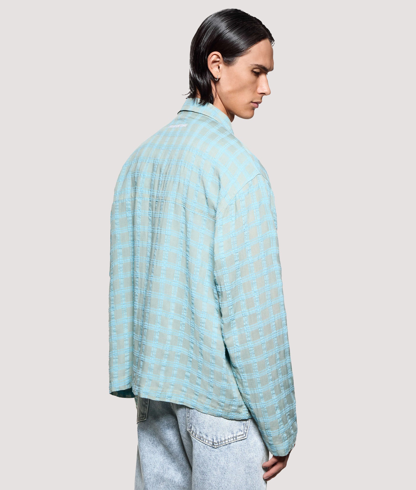 MKI MIYUKI ZOKU Box Fit Grid Check Rider in Sage at EQVVS Menswear. Angled model back shot.