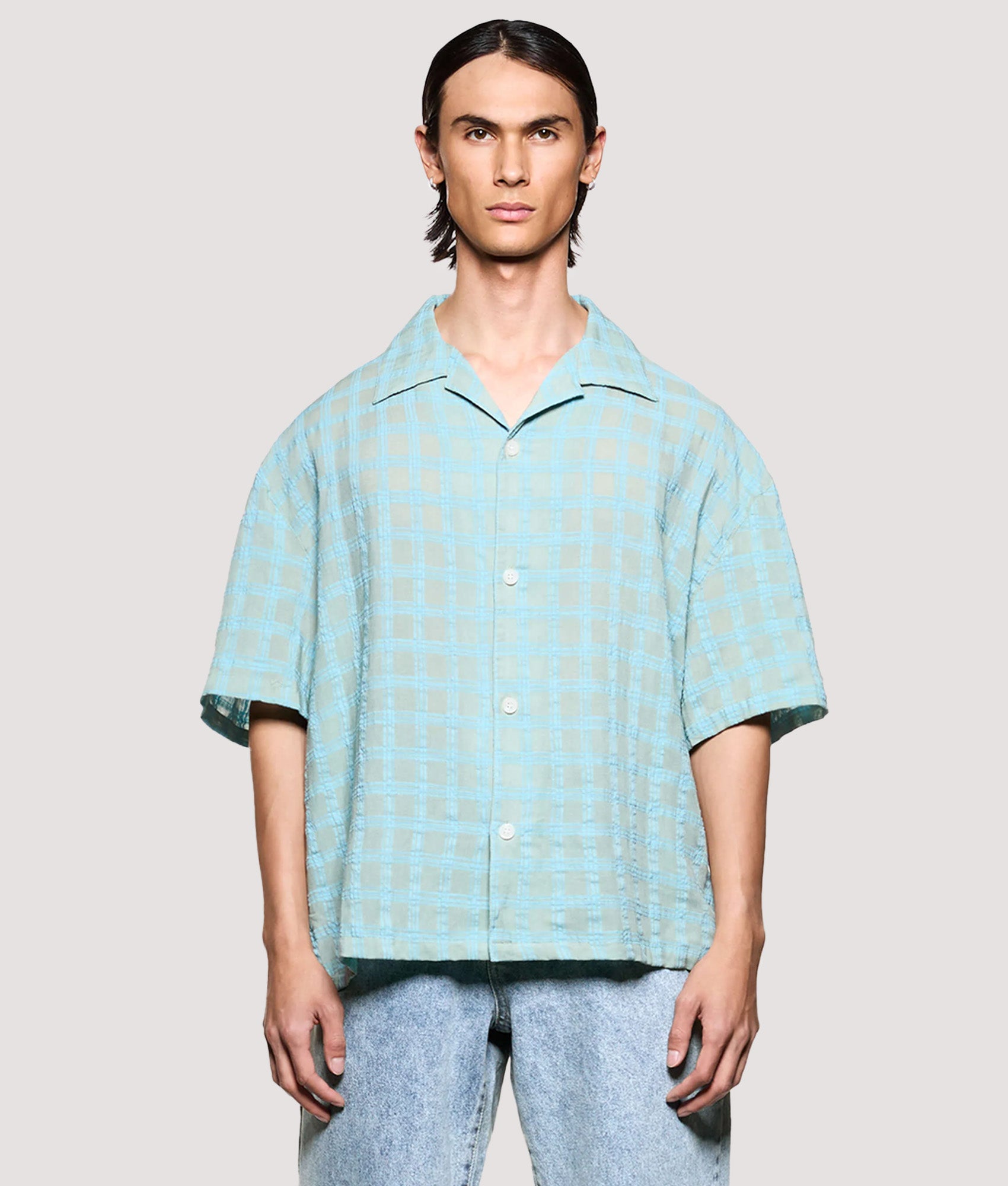 MKI MIYUKI ZOKU Box Fit Grid Check Short Sleeve Vacation Shirt in sage at EQVVS Menswear. Model front shot.
