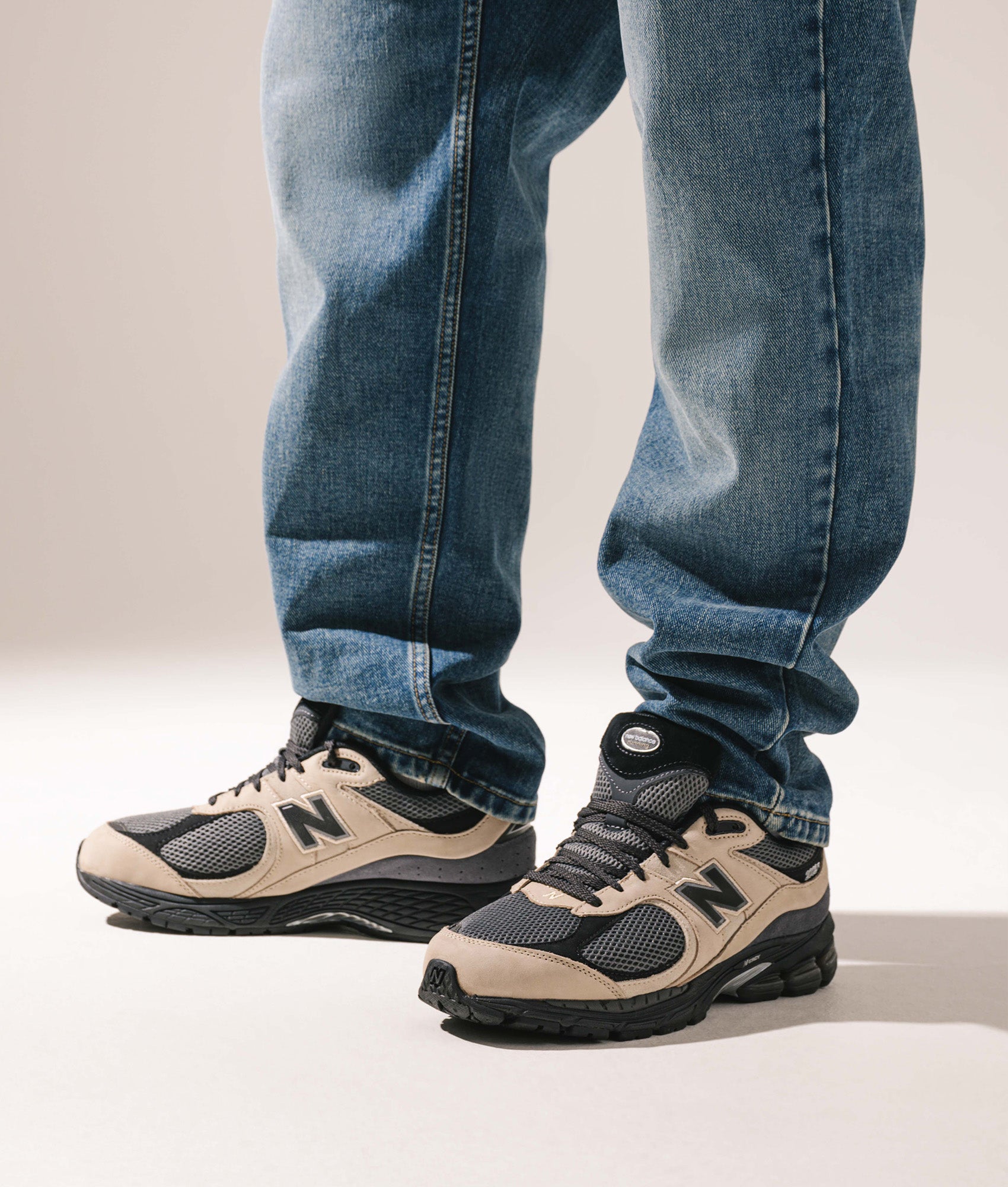 New Balance 2002R Sneakers in Stoneware at EQVVS Menswear. Model shot.