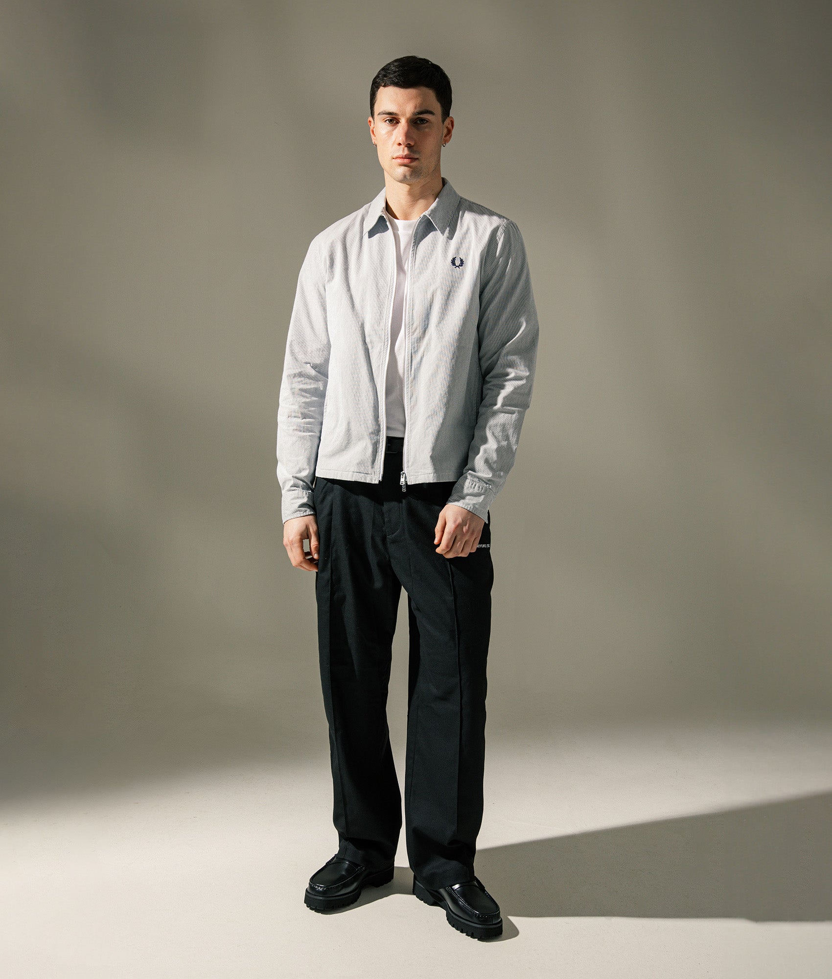 Fred Perry Striped Seersucker Zip Through Overshirt in Blue and White at EQVVS Menswear. Campaign shot.