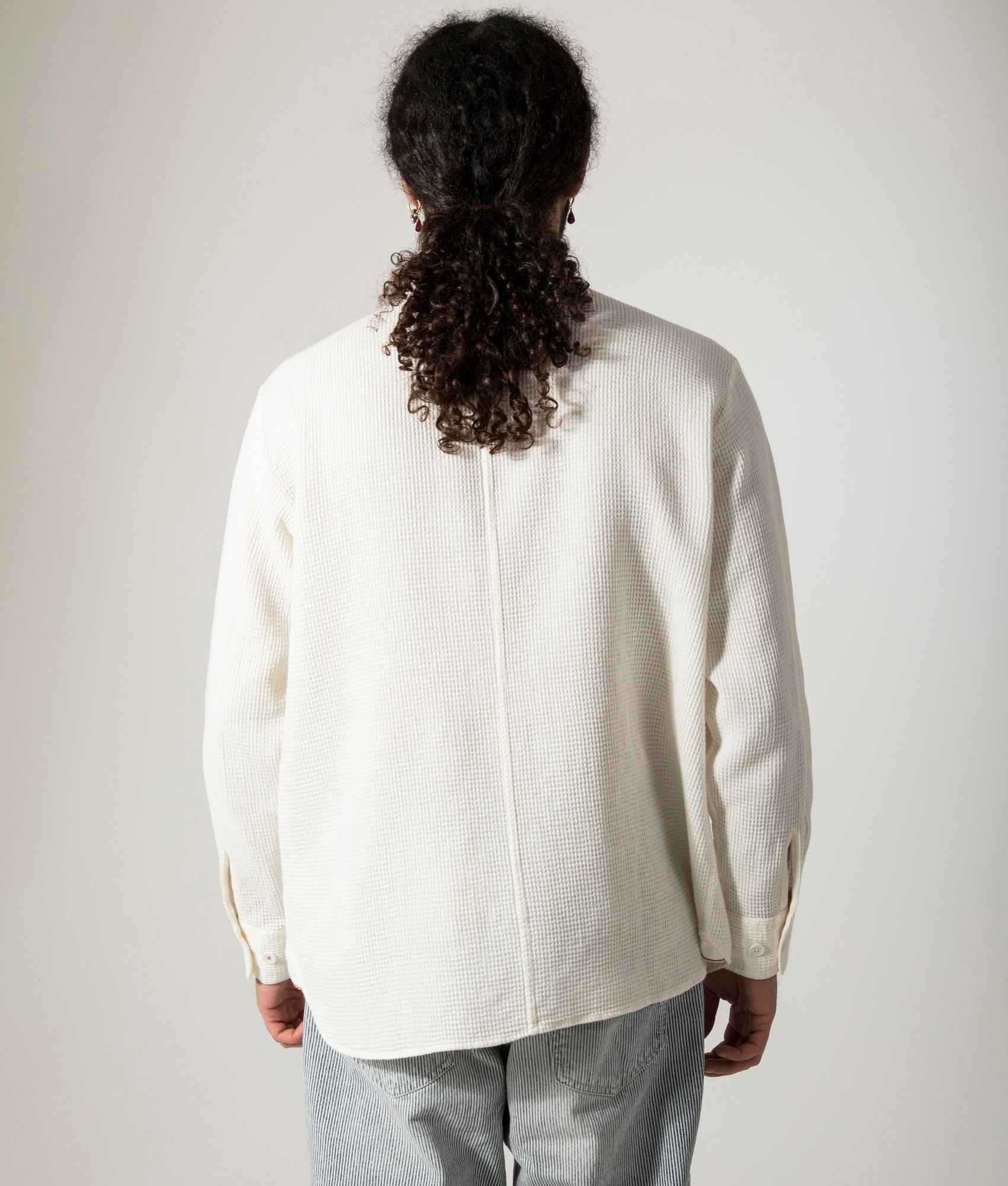 Universal Works Travail Overshirt in Ecru. Shot at EQVVS. Model back shot. 
