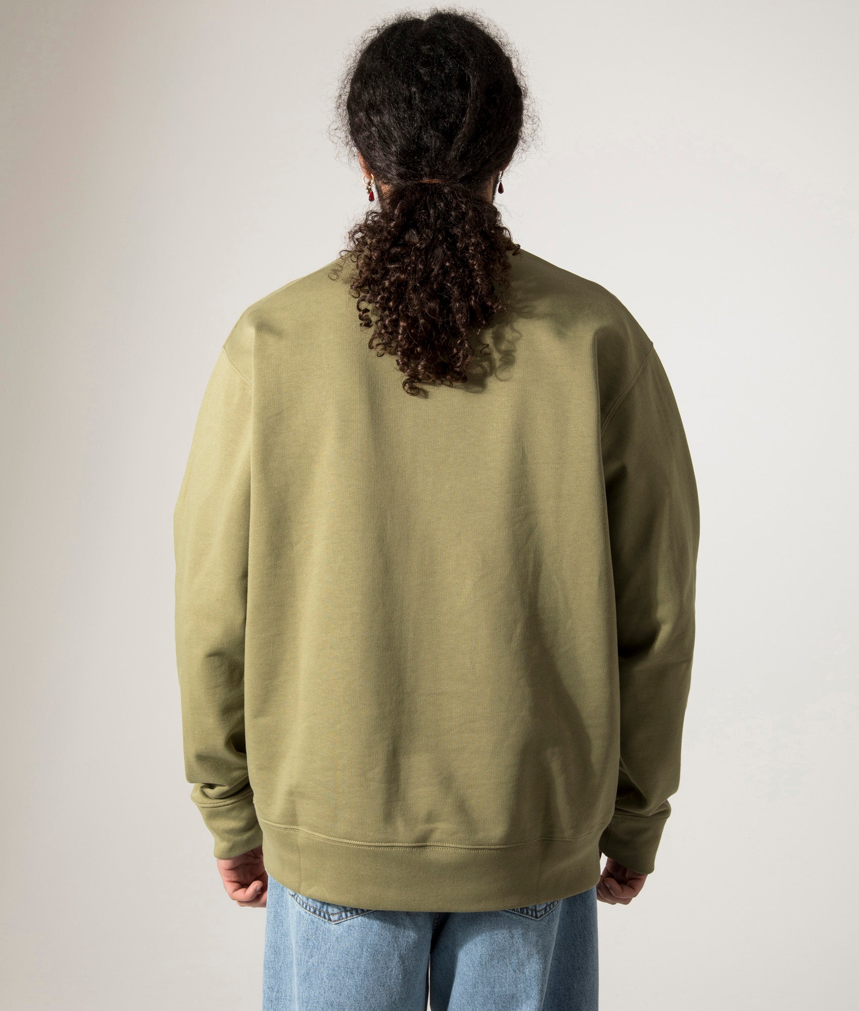 Norse Projects Relaxed Fit Ketel Quarter Zip Sweatshirt in Moss Green. Shot at EQVVS. Model back shot. 