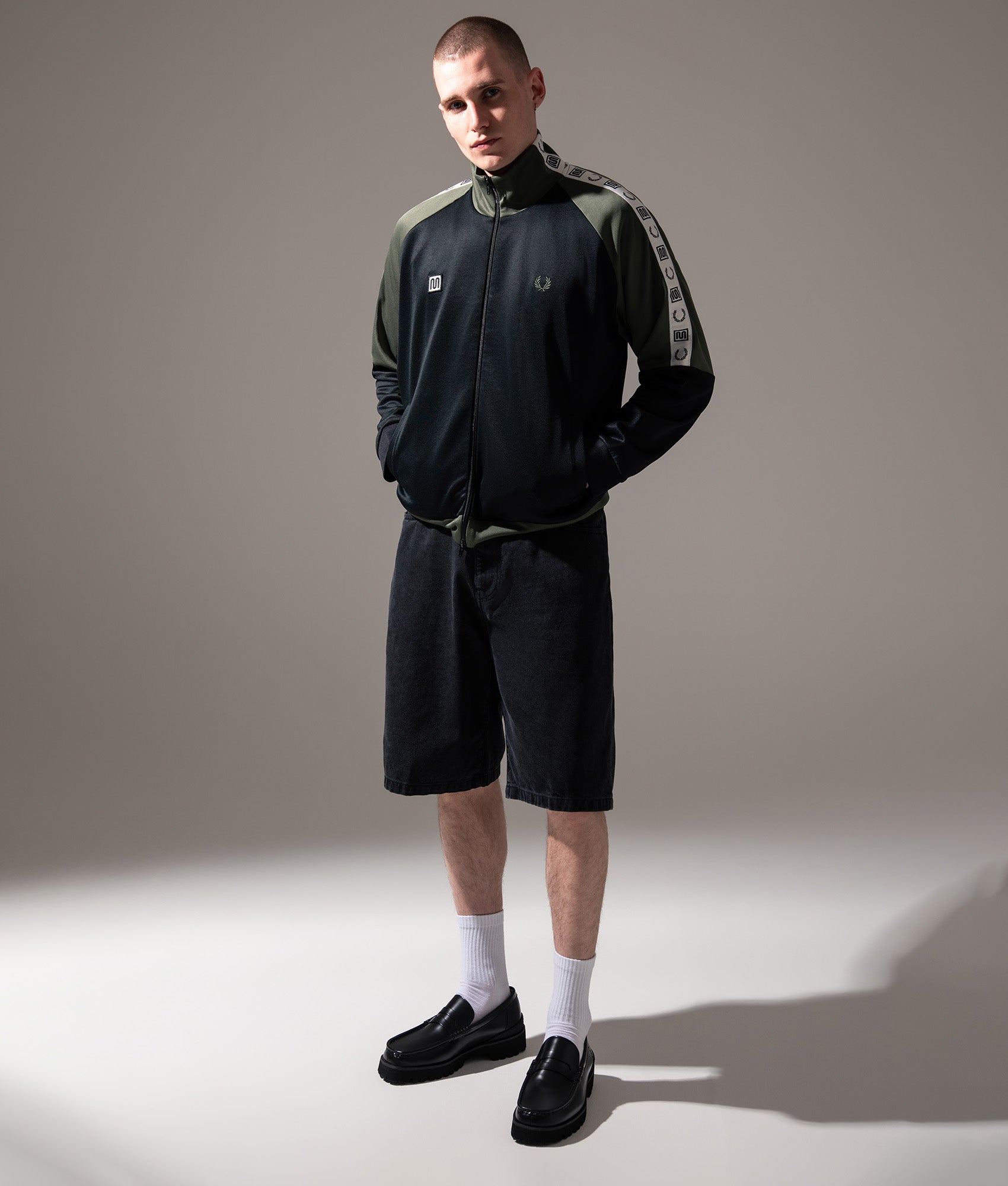 Fred Perry Meyba Taped Raglan Track Jacket in Black at EQVVS Menswear. Campaign shot.