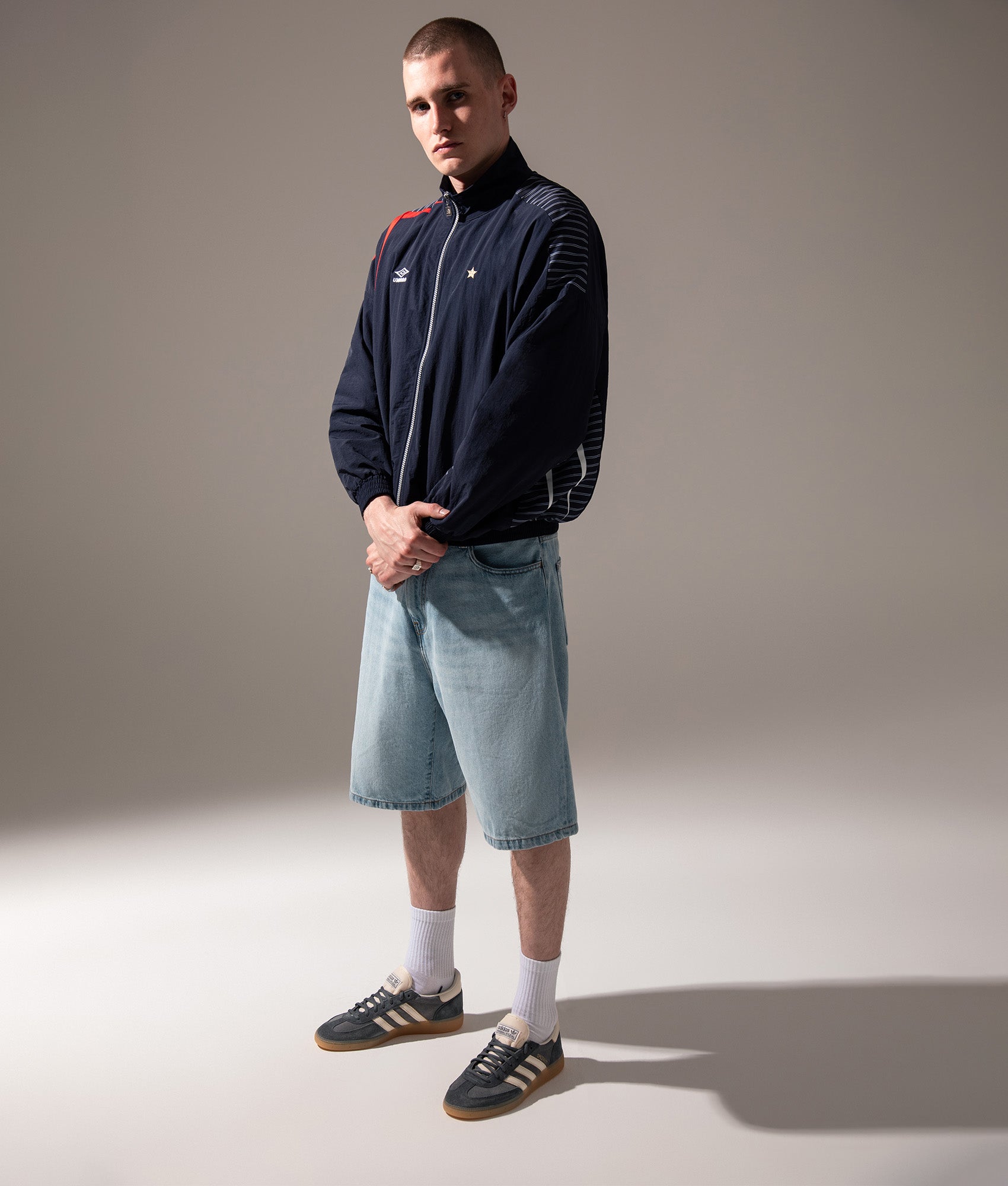 Umbro Relaxed Fit Track Jacket in Baritone Blue, Brilliant White and Goji B at EQVVS Menswear. Campaign shot.