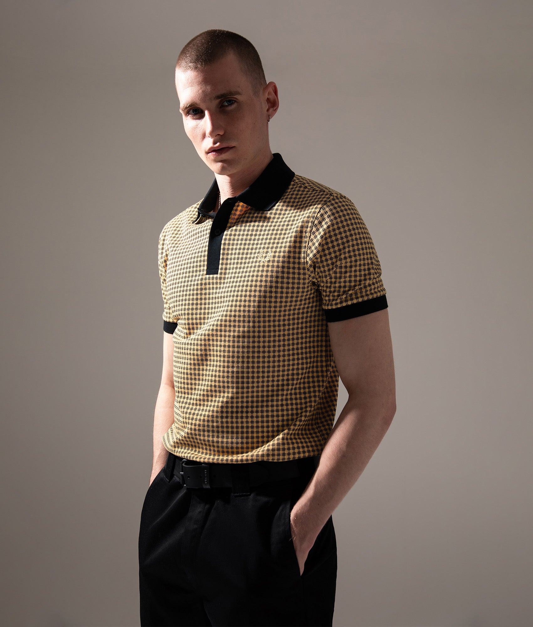 Fred Perry Cross Print Polo Shirt in Black at EQVVS Menswear. Campaign shot.