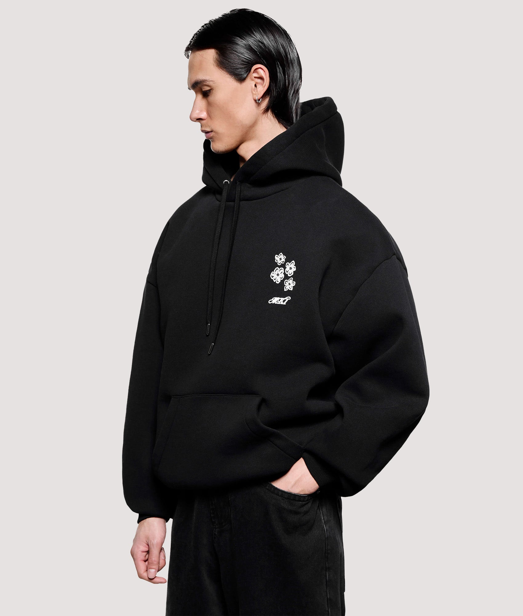 MKI MIYUKI ZOKU Box Fit Hibiscus Hoodie in Black at EQVVS Menswear. Angled model front shot.