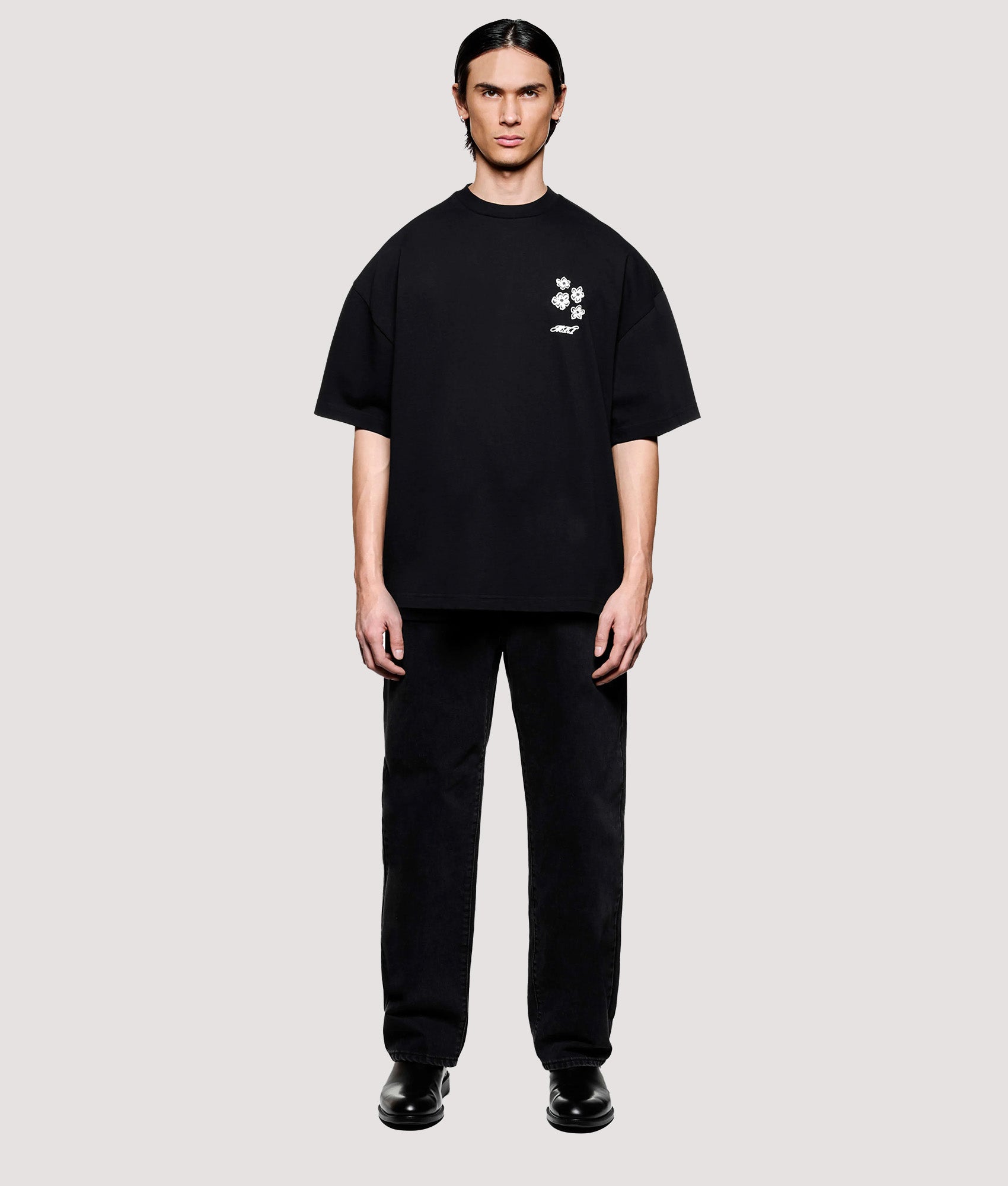 MKI MIYUKI ZOKU Box Fit Hibiscus T-Shirt in Black at EQVVS Menswear. Model full front shot.