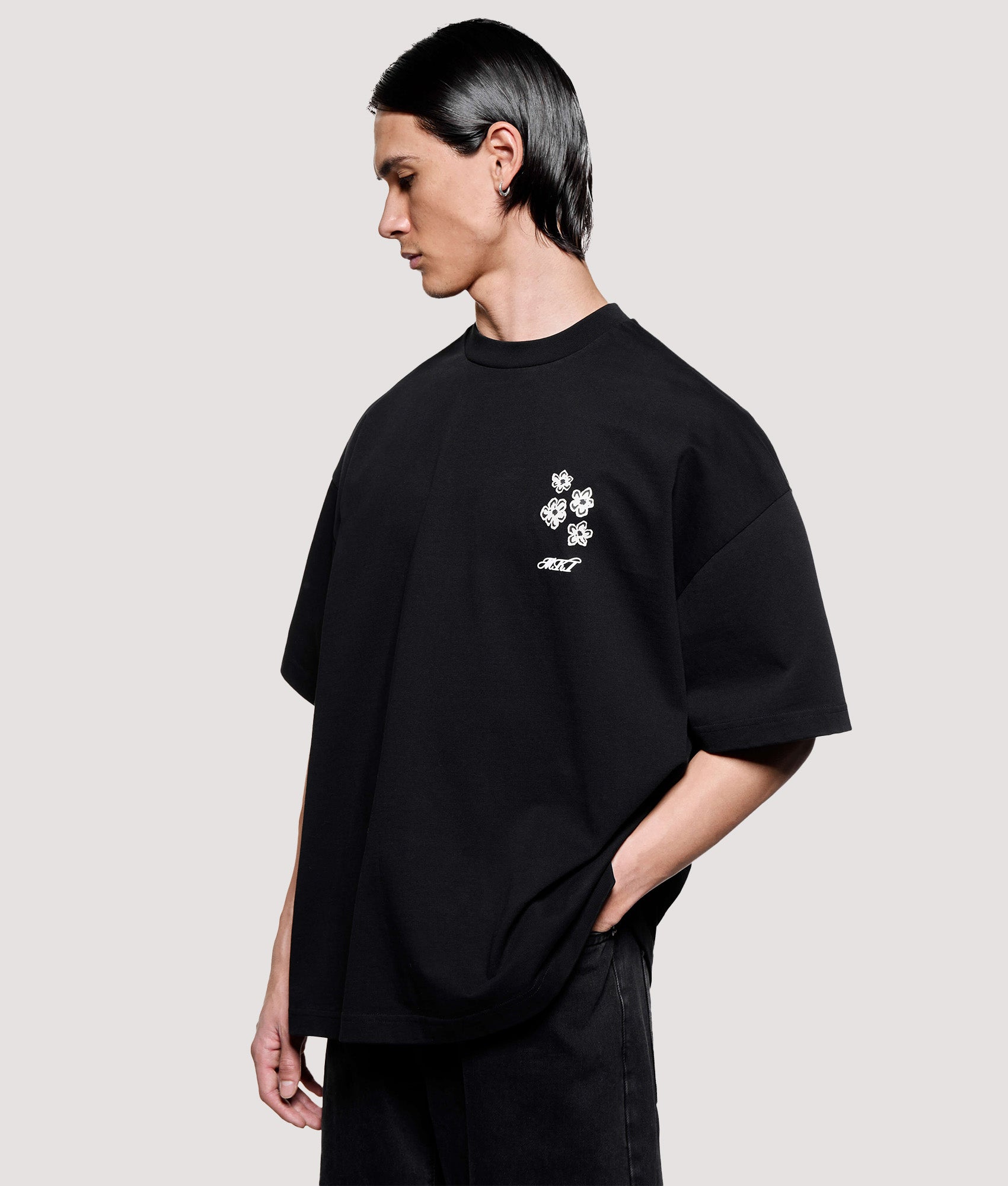 MKI MIYUKI ZOKU Box Fit Hibiscus T-Shirt in Black at EQVVS Menswear. Angled model front shot.