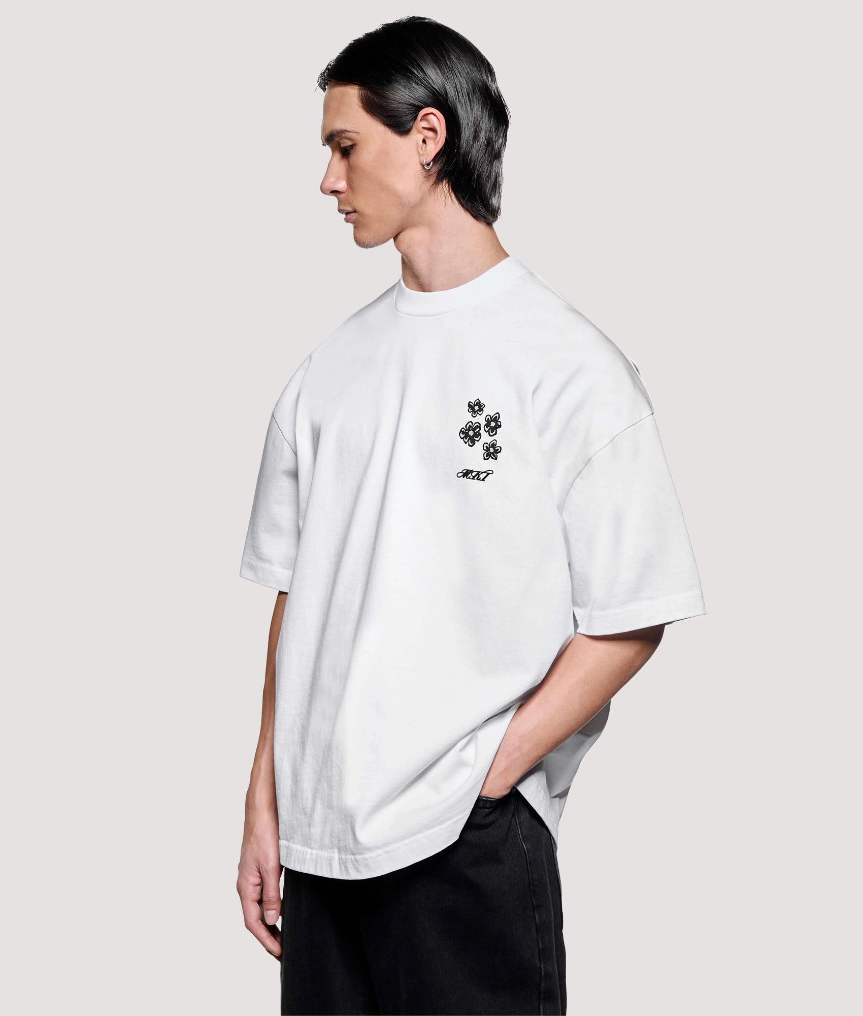 MKI MIYUKI ZOKU Box Fit Hibiscus T-Shirt in White at EQVVS Menswear. Model front shot.