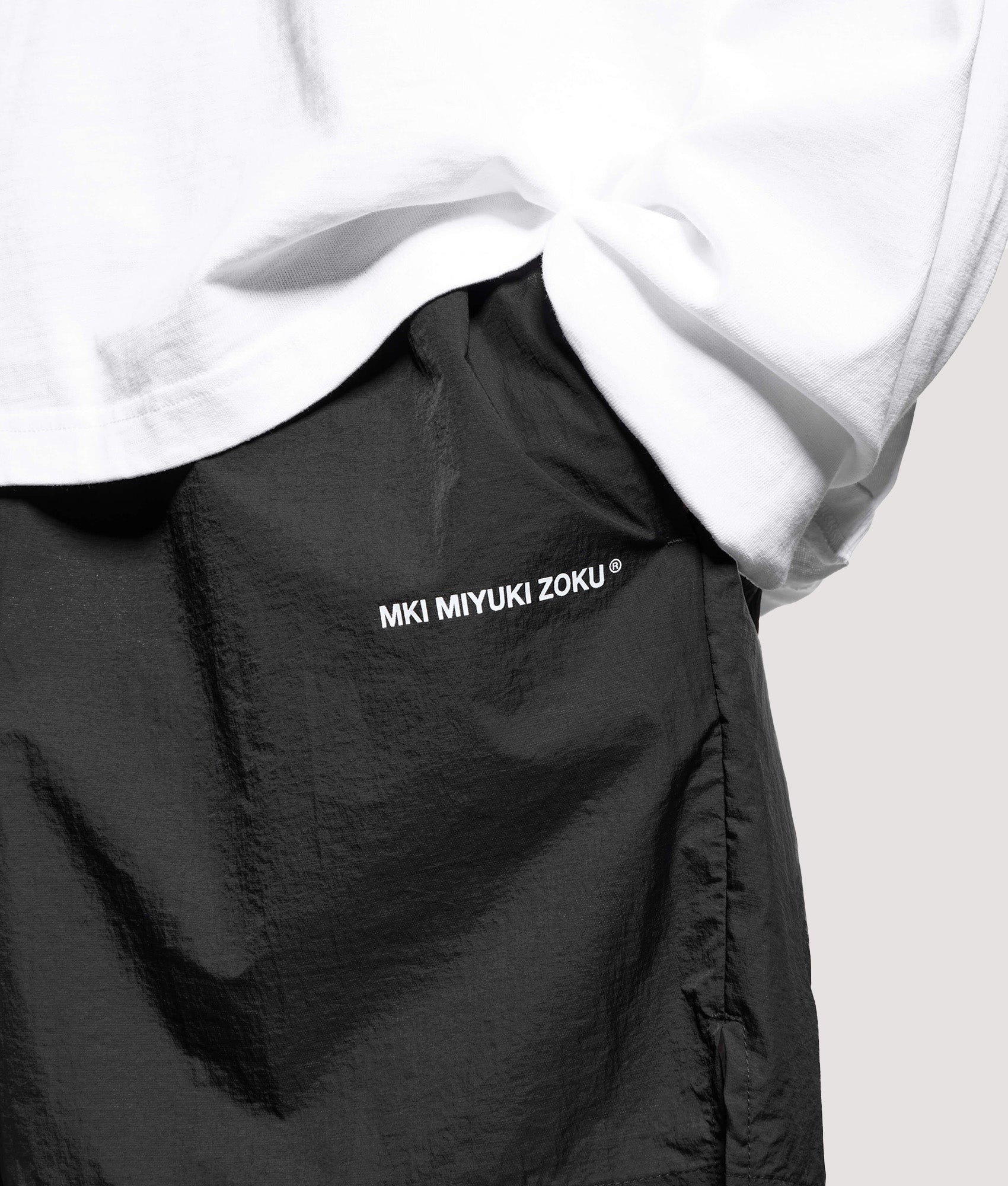 MKI MIYUKI ZOKU Relaxed Fit Hyperlight Wind Shorts in Black at EQVVS Menswear. Detail shot.