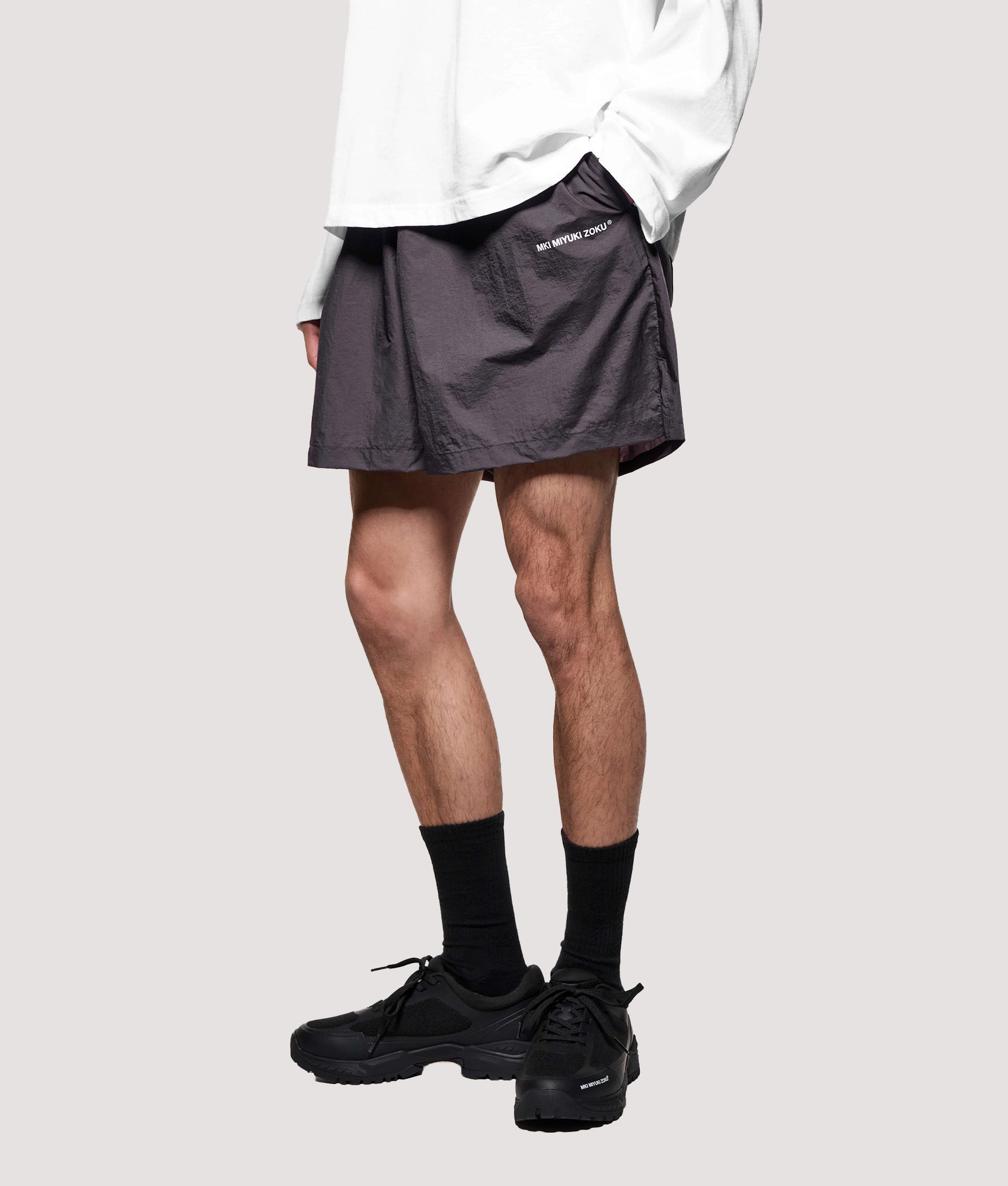 MKI MIYUKI ZOKU Relaxed Fit Hyperlight Wind Shorts in Raisin at EQVVS Menswear. Model angled front shot.