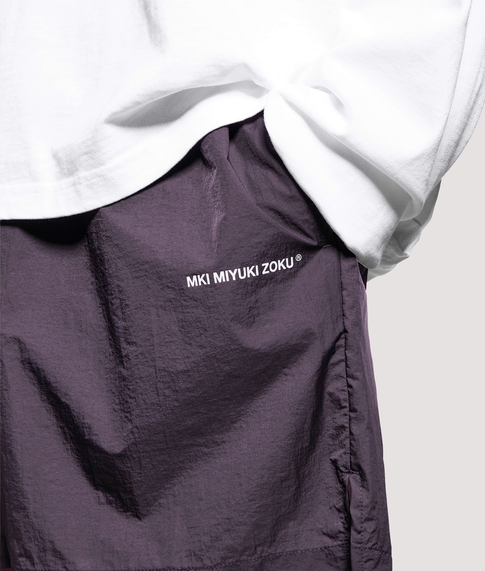 MKI MIYUKI ZOKU Relaxed Fit Hyperlight Wind Shorts in Raisin at EQVVS Menswear. Detail shot.