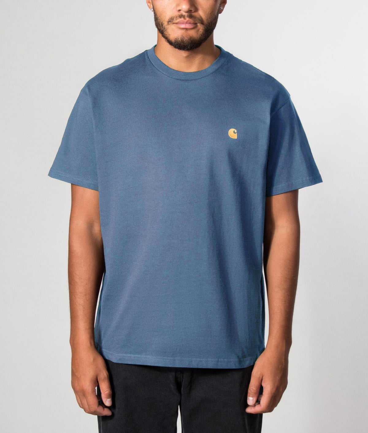 Carhartt WIP Loose Fit Chase T-Shirt in Icesheet and Gold at EQVVS Menswear. Front model shot.