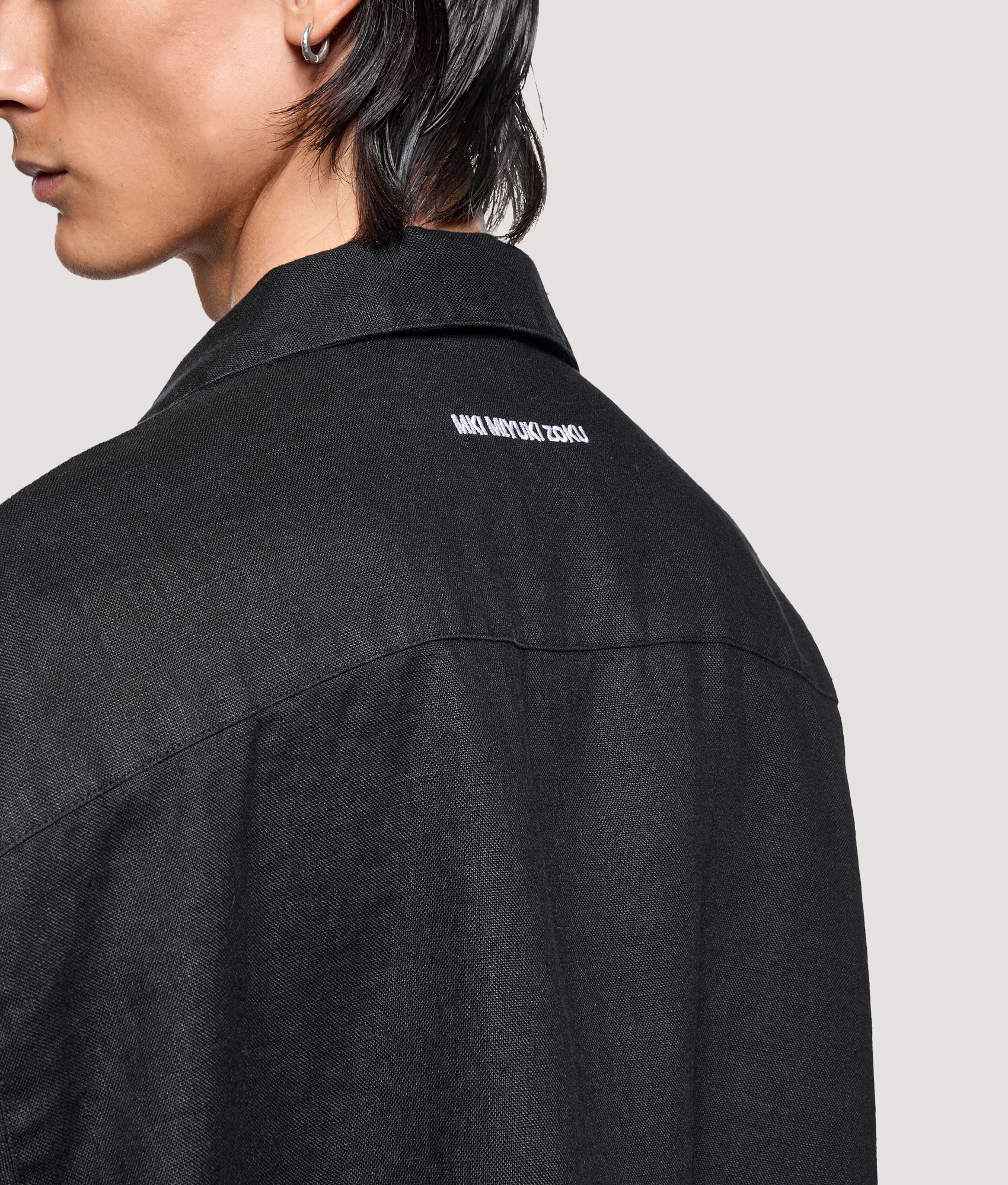 MKI MIYUKI ZOKU Box Fit Linen Short Sleeve Vacation Shirt in Black at EQVVS Menswear. Angled model detail shot.