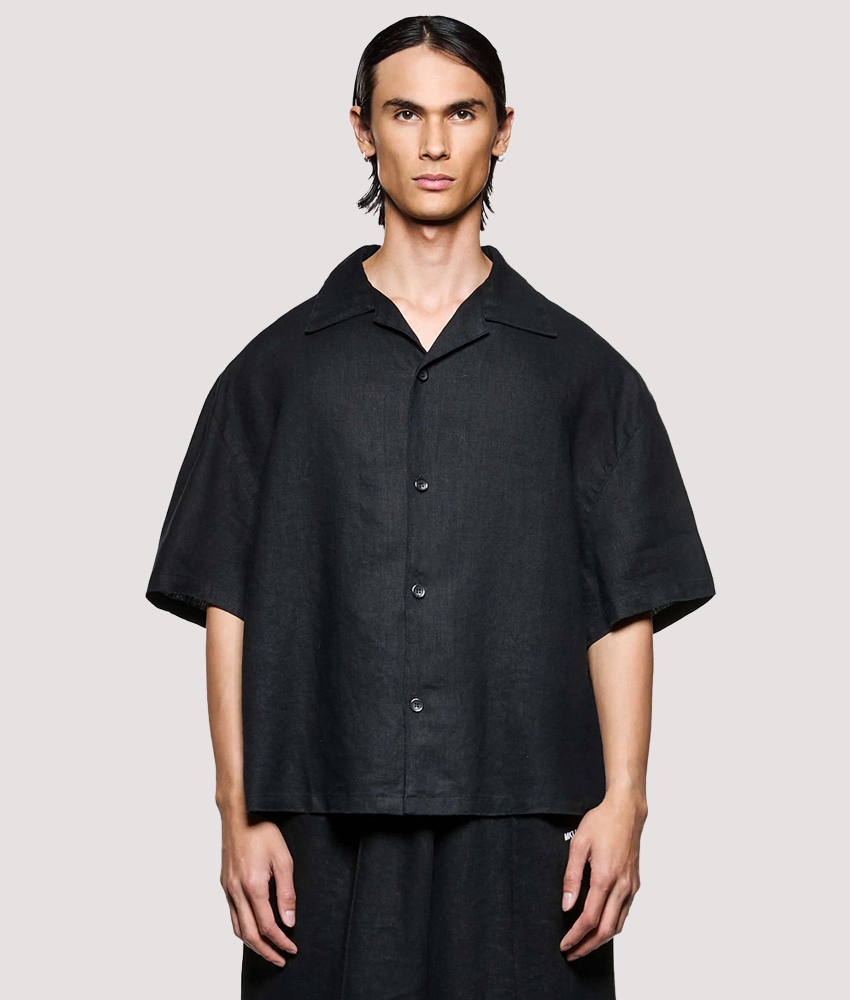 MKI MIYUKI ZOKU Box Fit Linen Short Sleeve Vacation Shirt in Black at EQVVS Menswear. Model front shot.