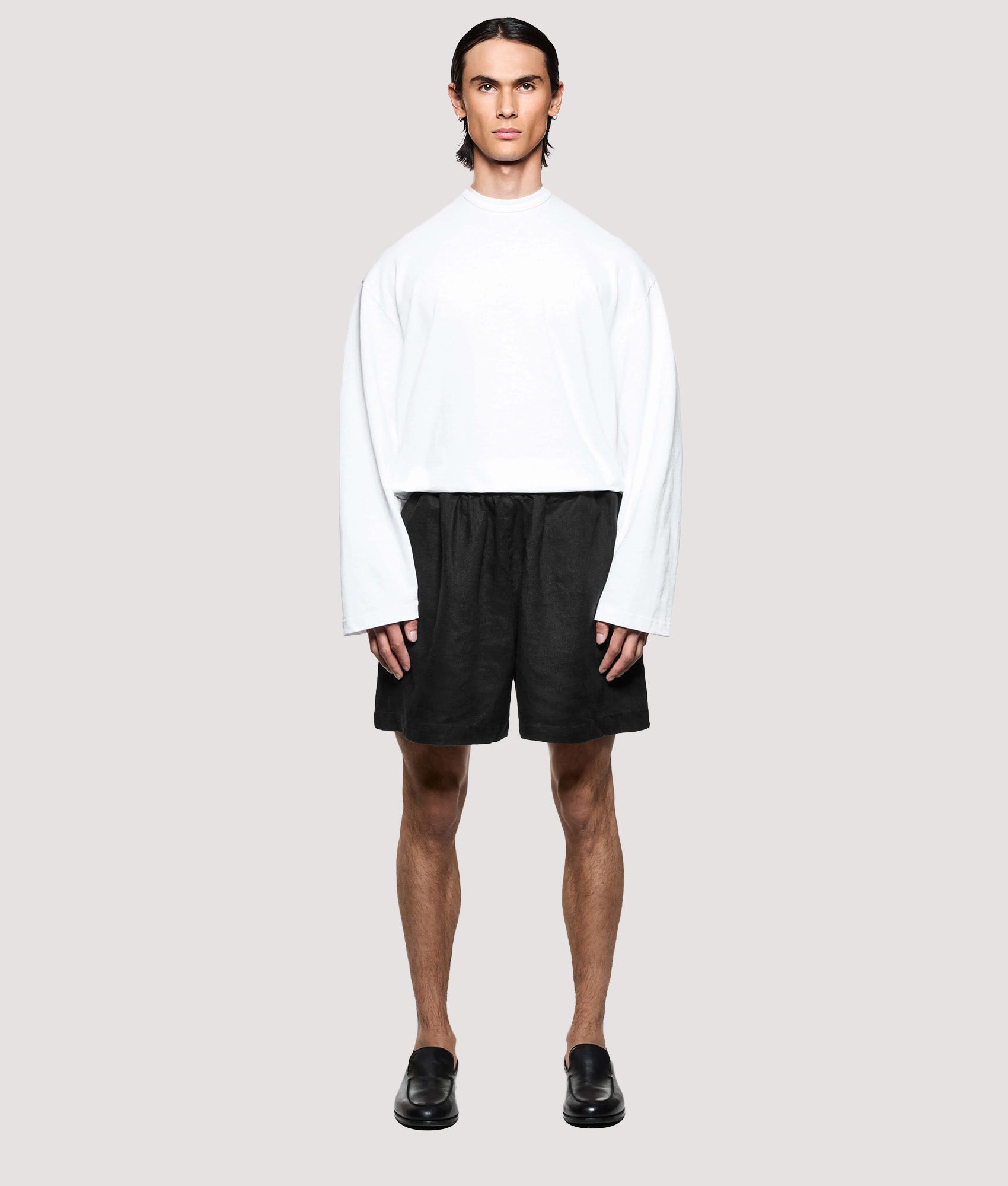 MKI MIYUKI ZOKU Relaxed Fit Linen Wide Leg Shorts in Black at EQVVS Menswear. Model full front shot.