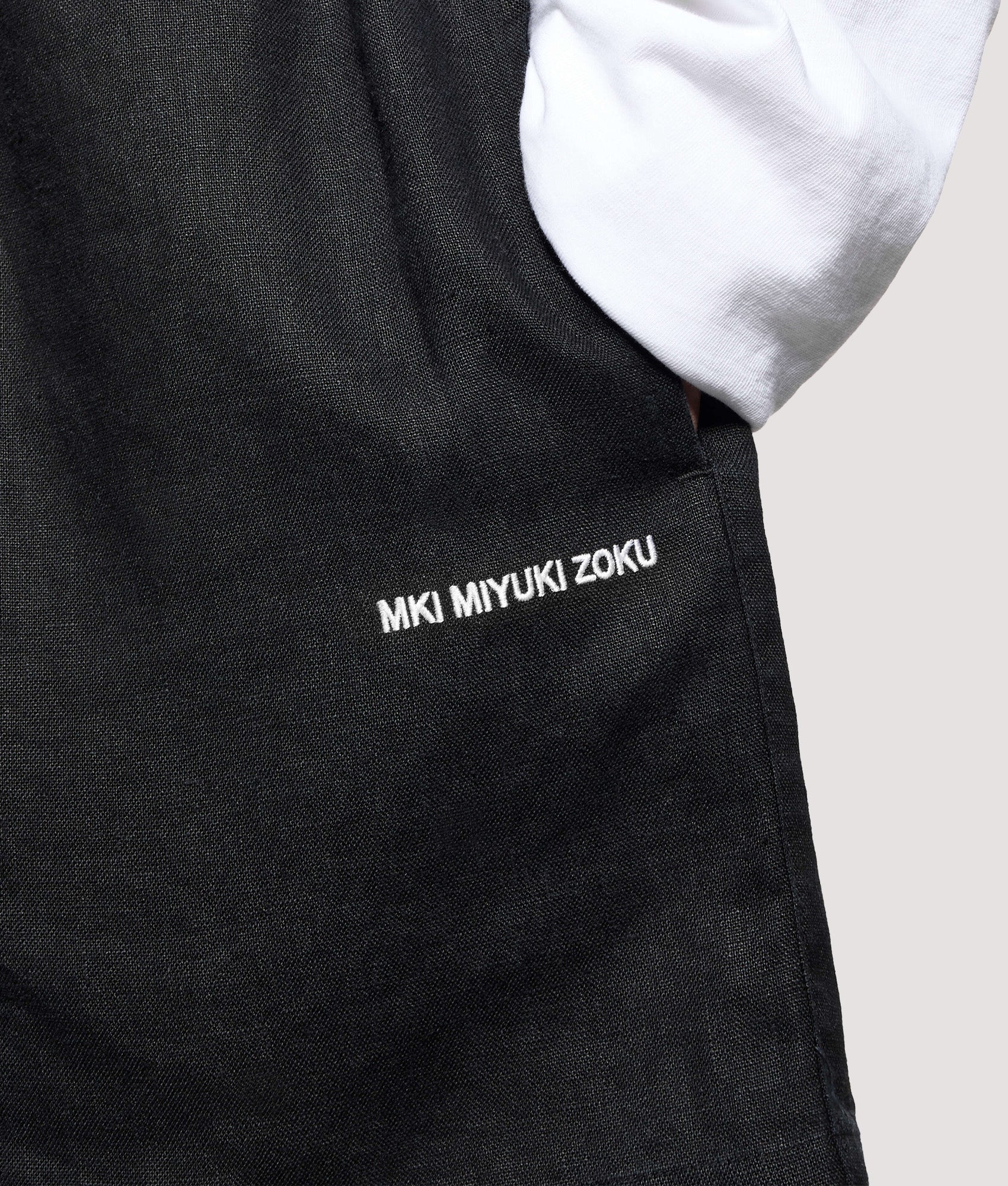 MKI MIYUKI ZOKU Relaxed Fit Linen Wide Leg Shorts in Black at EQVVS Menswear. Detail shot.