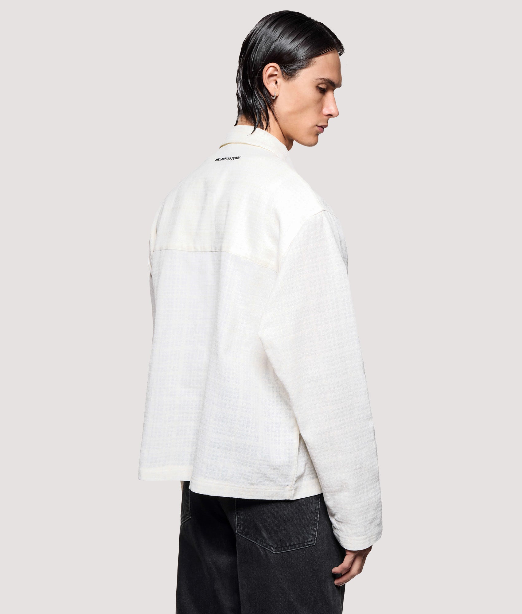 MKI MIYUKI ZOKU Box Fit Loose Weave Check Rider in Bone at EQVVS Menswear. Angled model back shot.