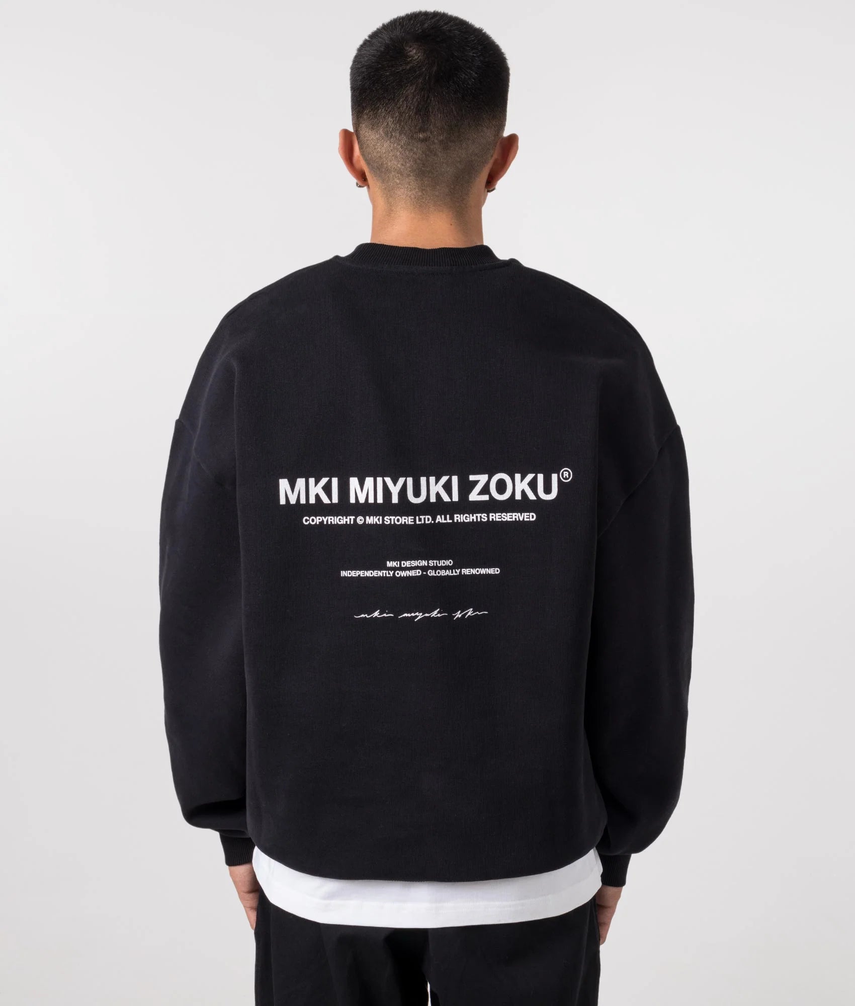 MKI MIYUKI ZOKU Oversized studio sweatshirt in Black at EQVVS Menswear. Model back shot.