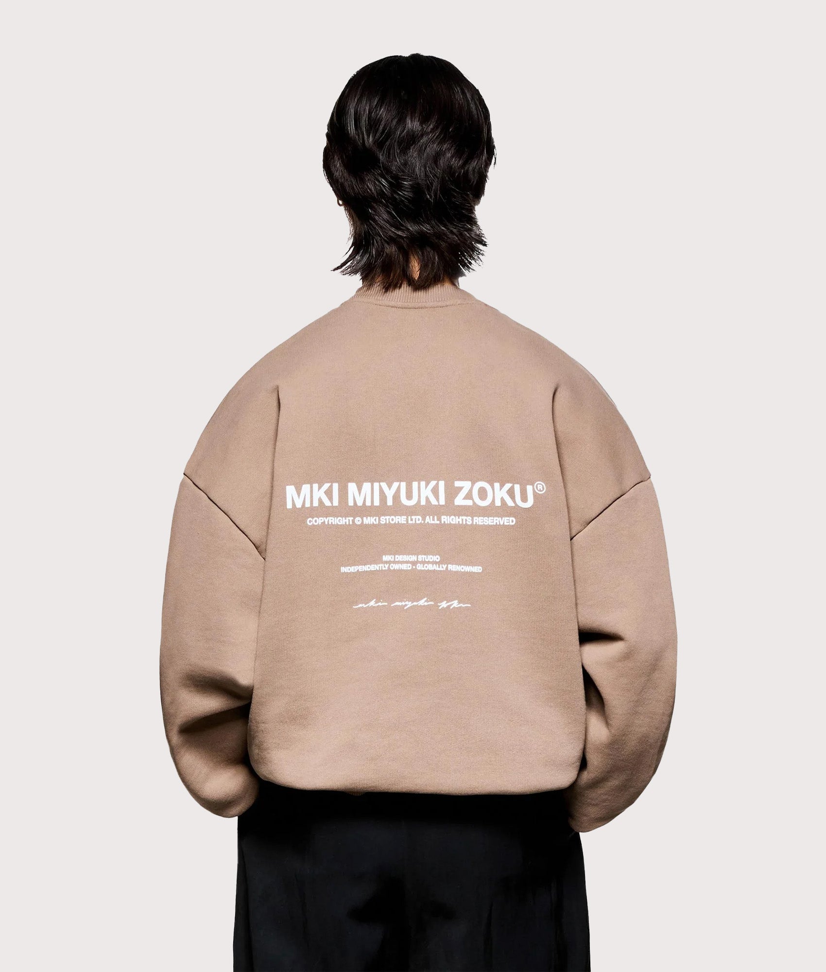 MKI MIYUKI ZOKU Oversized Design Studio Crewneck Sweatshirt in Mushroom. Model Back shot.