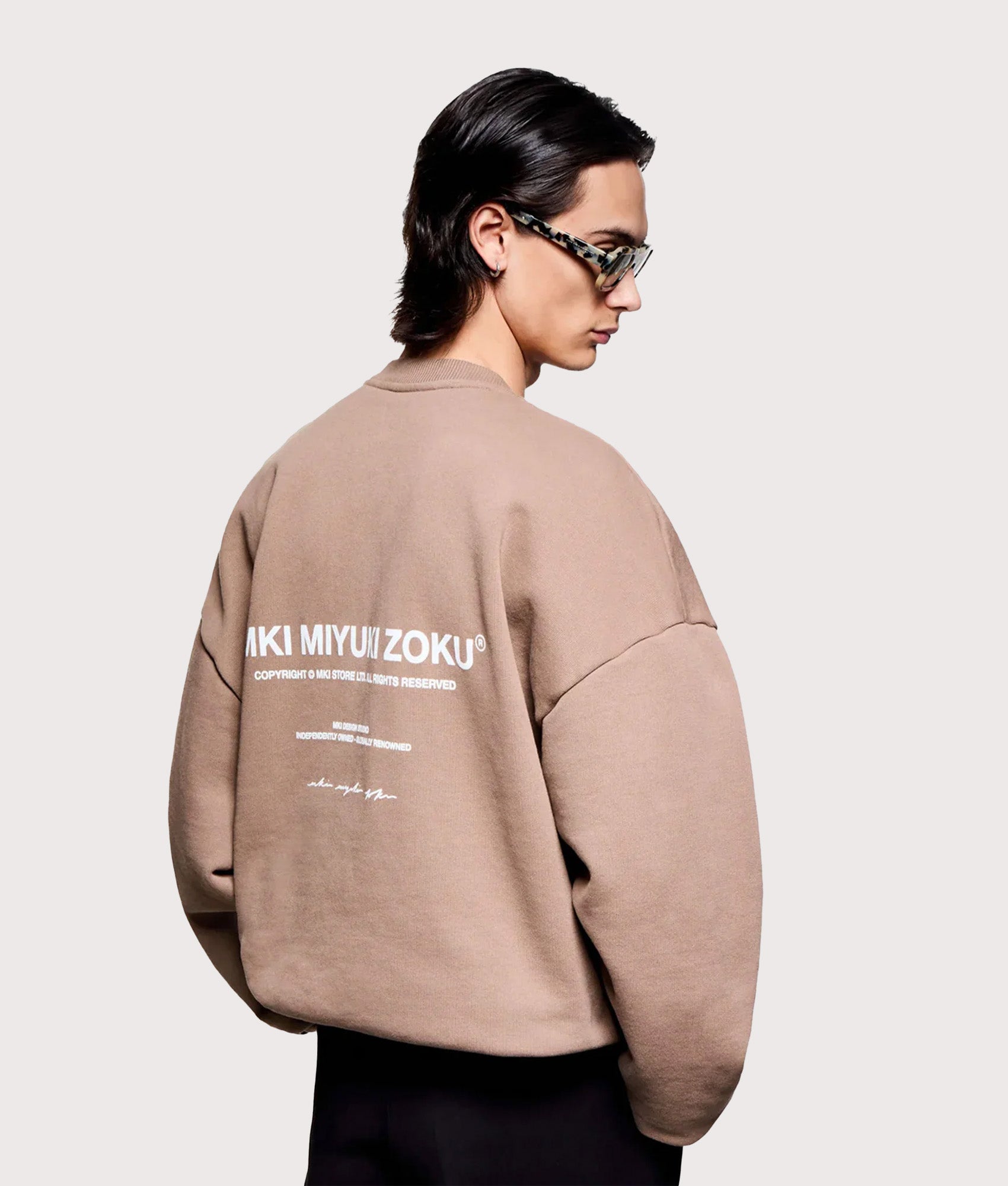 MKI MIYUKI ZOKU Oversized Design Studio Crewneck Sweatshirt in Mushroom. Angled model back shot.