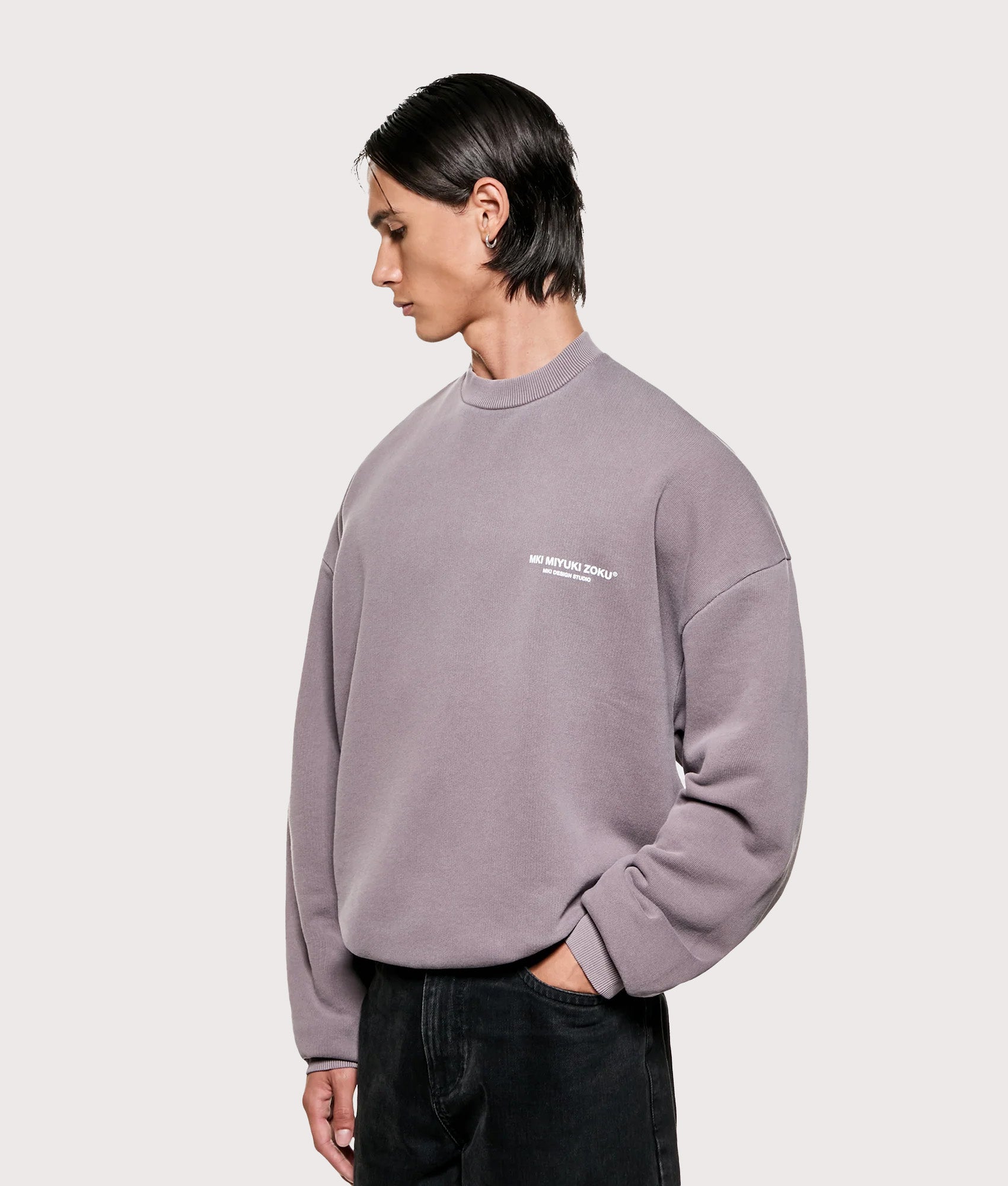 MKI MIYUKI ZOKU Oversized Design Studio Crewneck Sweatshirt in Pigment Raisin. Angled model front shot.