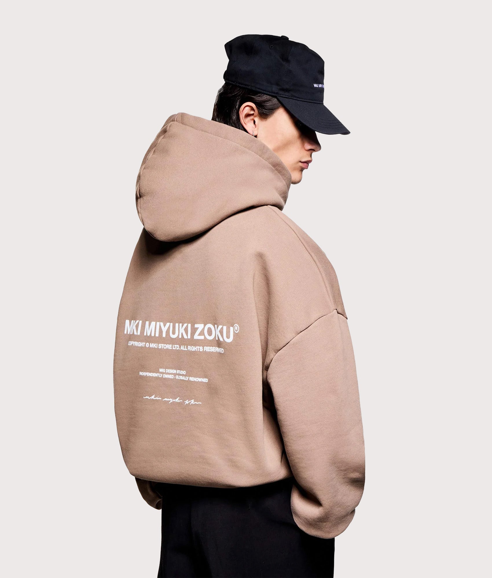 MKI MIYUKI ZOKU Oversized Design Studio Hoodie in Mushroom at EQVVS Menswear. Angled model back shot.