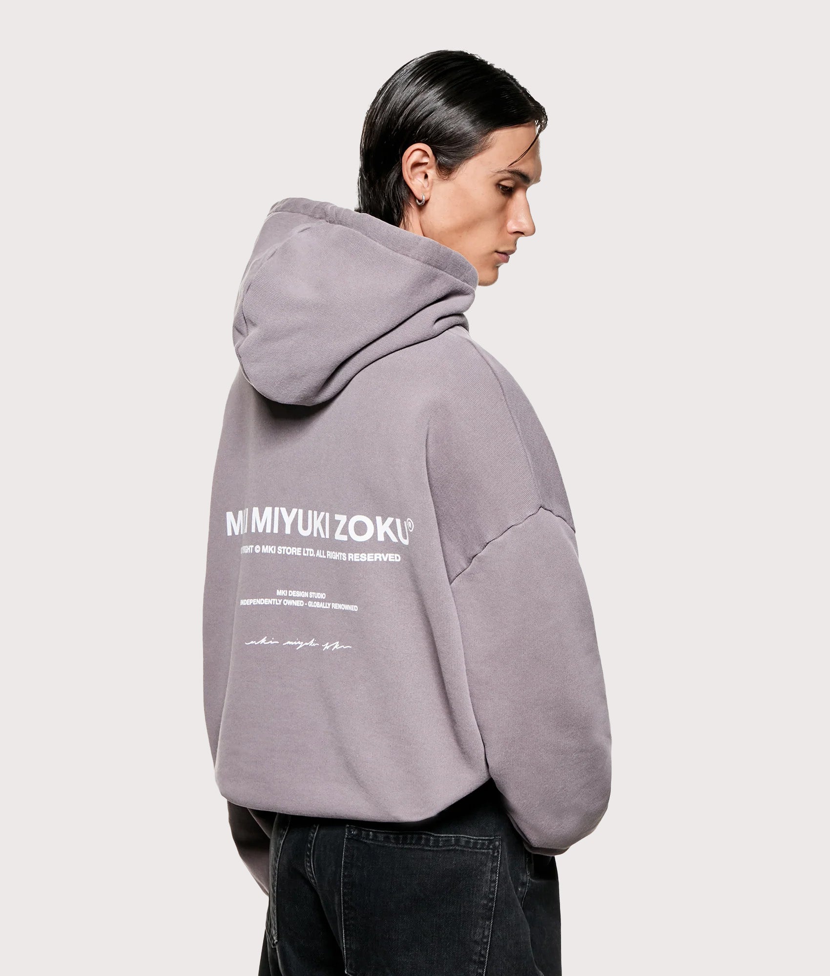 MKI MIYUKI ZOKU Oversized Design Studio Hoodie in Pigment Raisin at EQVVS Menswear. Angled model Back shot.