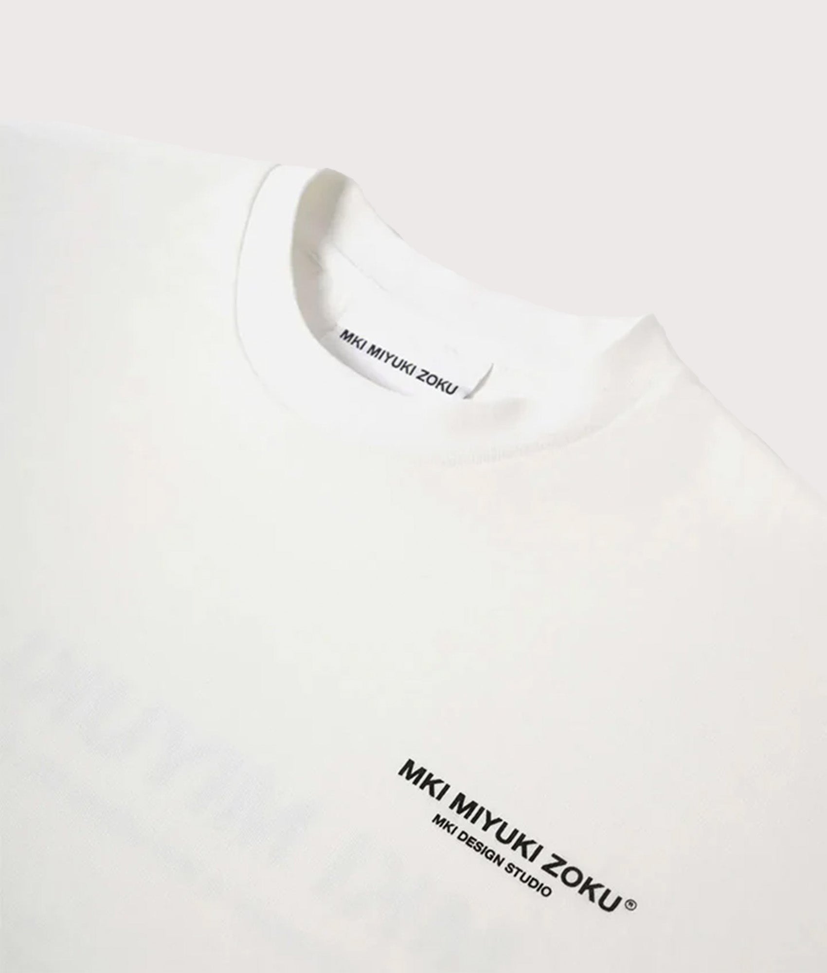 MKI MIYUKI ZOKU Oversized Fit Design Studio T-Shirt in White at EQVVS Menswear. Detail shot.