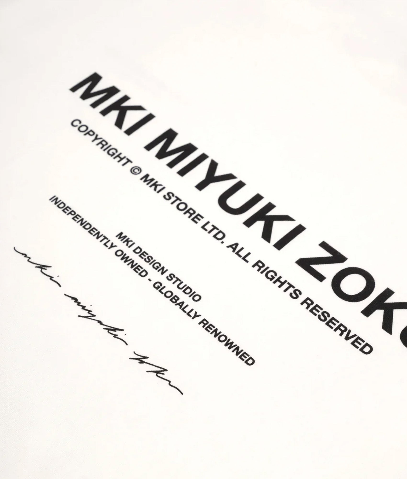 MKI MIYUKI ZOKU Oversized Fit Design Studio T-Shirt in White at EQVVS Menswear. Detail shot.