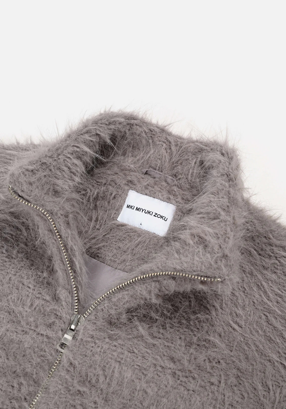 MKI Miyuki Zoku Faux Alpaca Track Jacket Light Grey. Detail shot. 