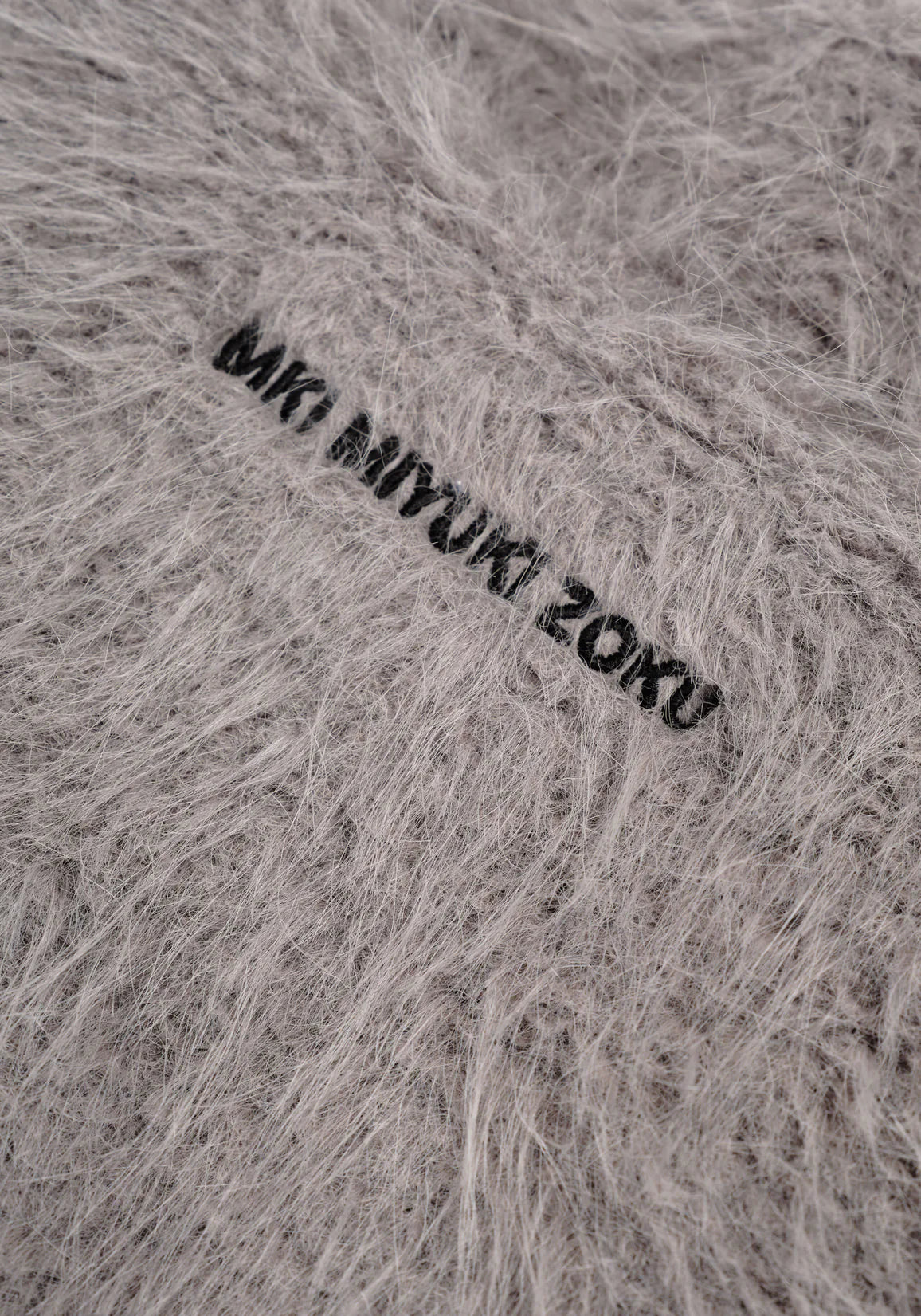 MKI Miyuki Zoku Faux Alpaca Track Jacket Light Grey. Detail shot. 