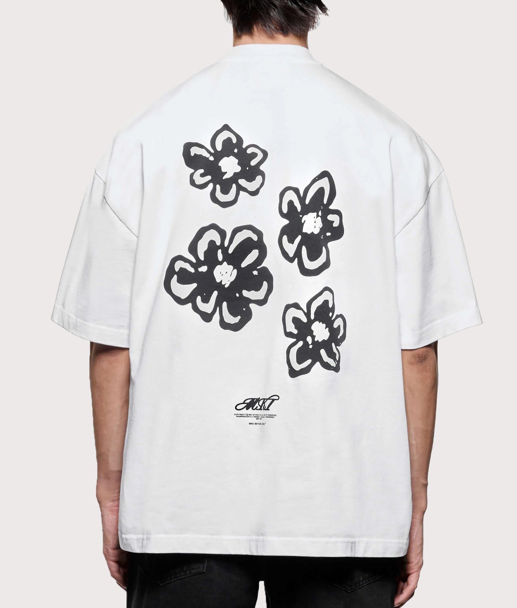 MKI MIYUKI ZOKU Box Fit Hibiscus T-Shirt in White at EQVVS Menswear. Model back shot.