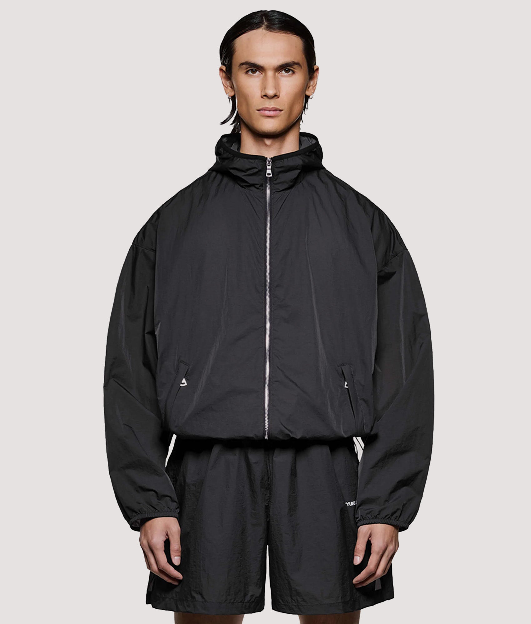 MKI MIYUKI ZOKU Box Fit Hyperlight Hooded Wind Jacket in Black at EQVVS Menswear. Model front shot.