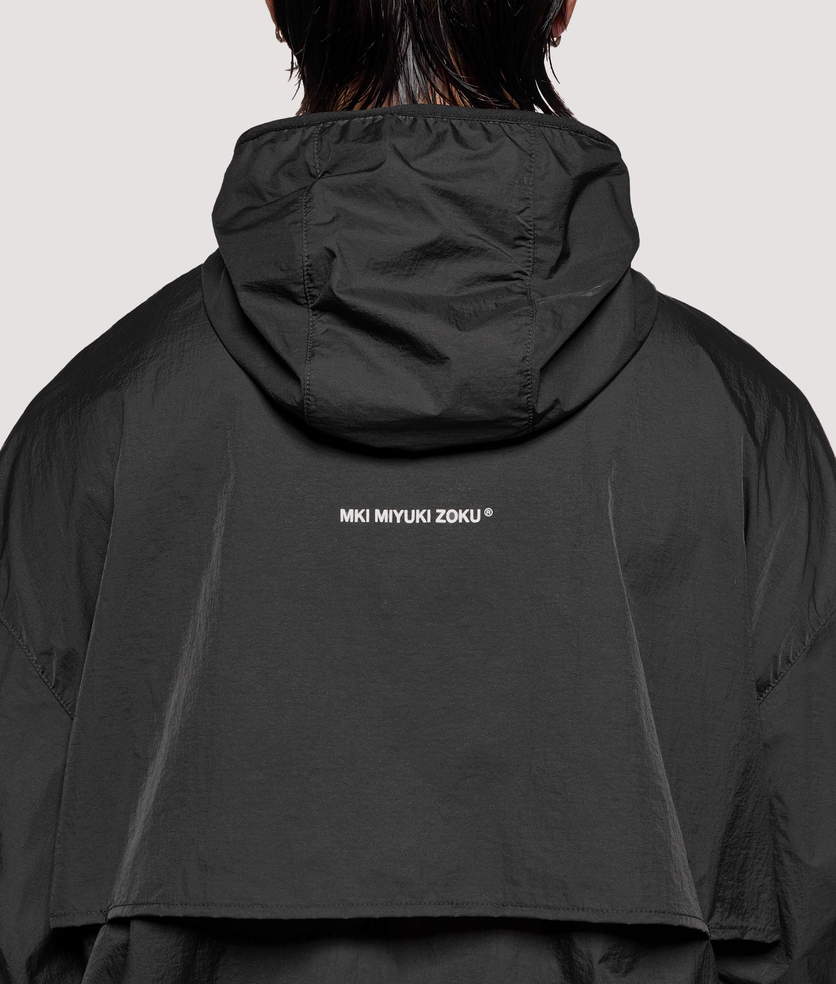 MKI MIYUKI ZOKU Box Fit Hyperlight Hooded Wind Jacket in Black at EQVVS Menswear. Detail shot.