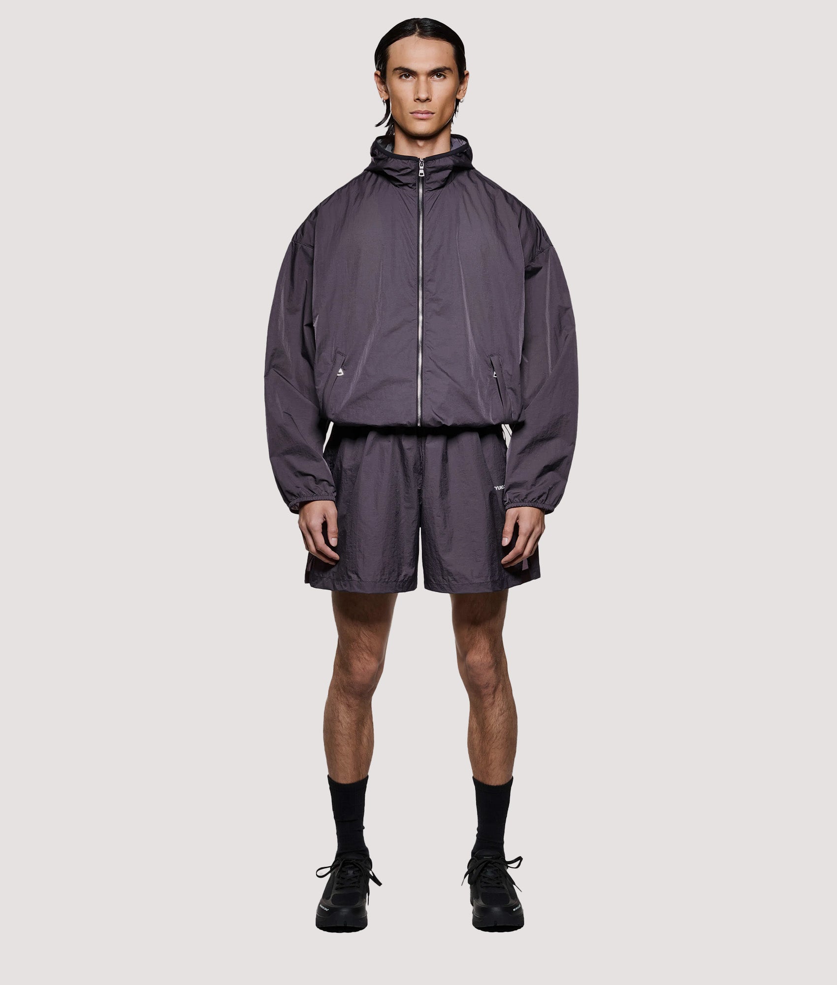 MKI MIYUKI ZOKU Box Fit Hyperlight Hooded Wind Jacket in Raisin at EQVVS Menswear. Model full front shot.