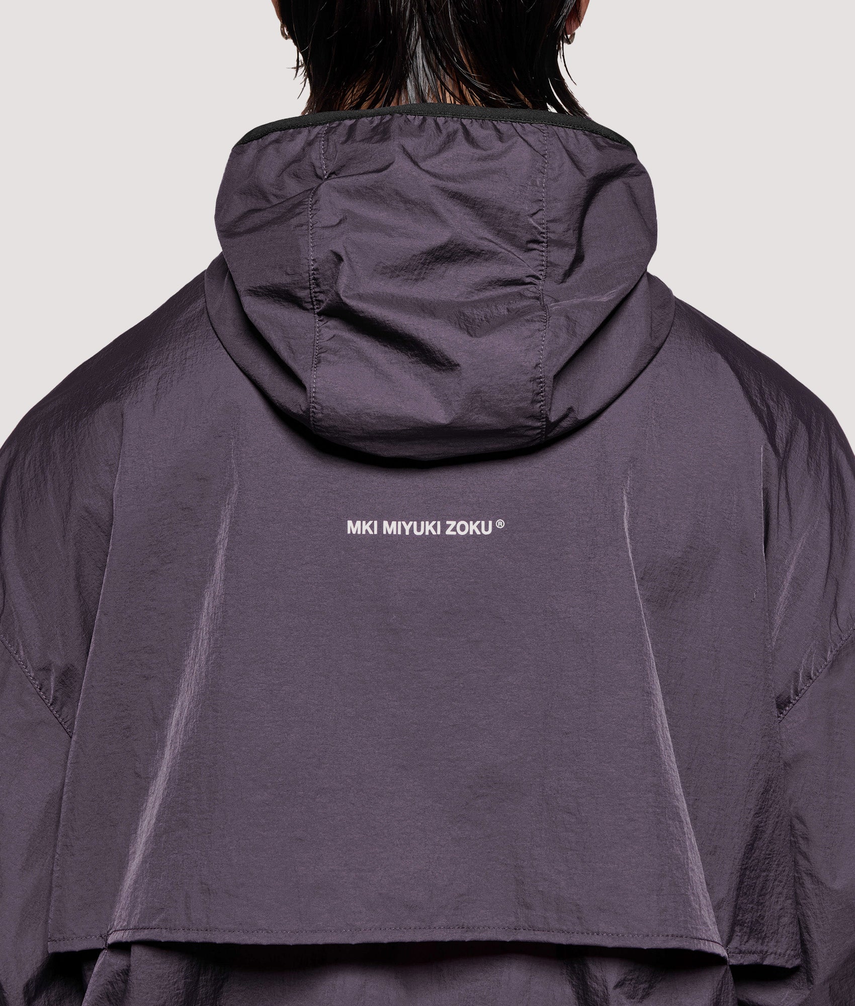 MKI MIYUKI ZOKU Box Fit Hyperlight Hooded Wind Jacket in Raisin at EQVVS Menswear. Detail shot.