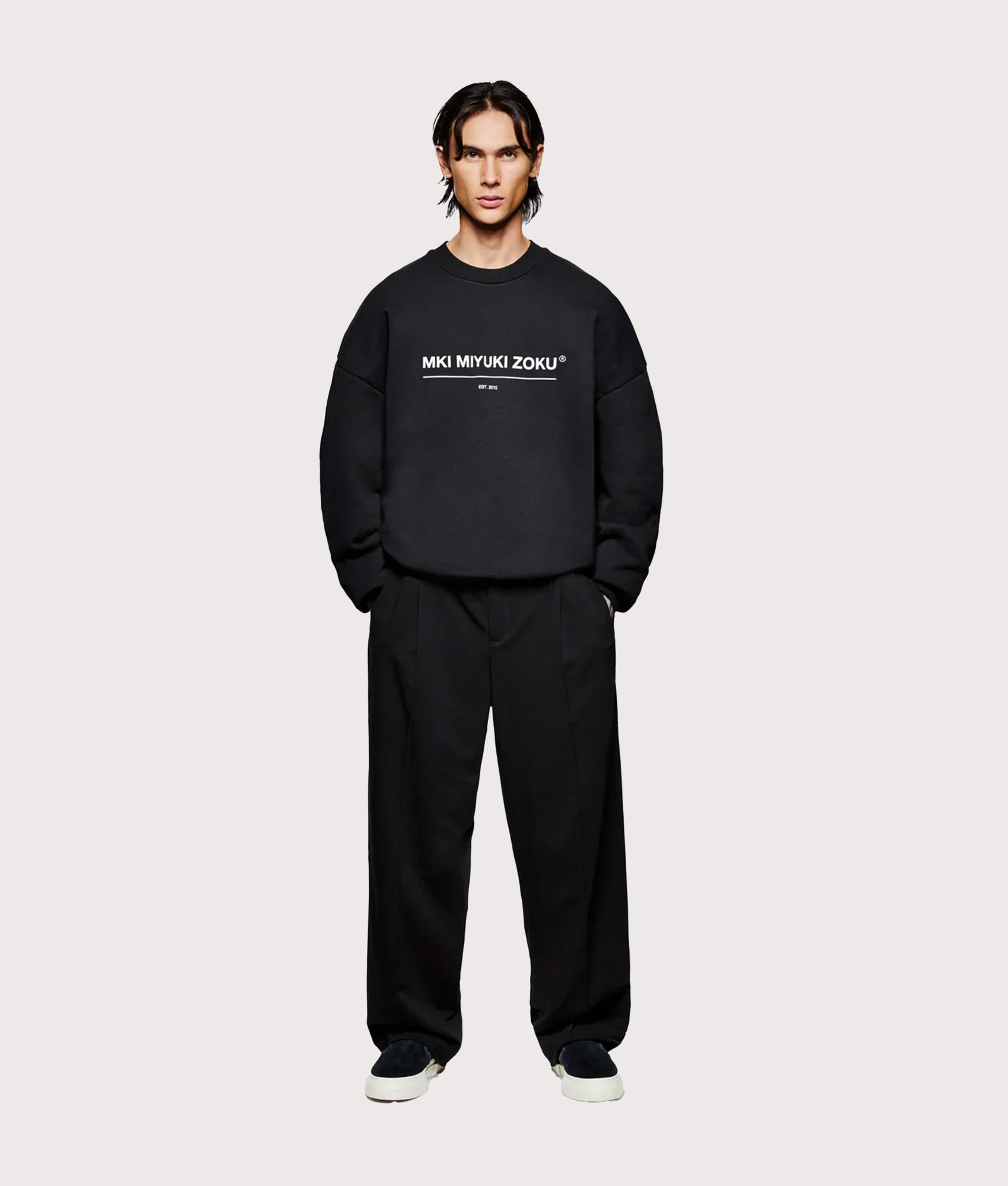 MKI MIYUKI ZOKU Oversized Linear Crewneck Sweatshirt in Black at EQVVS Menswear. Model full front shot.