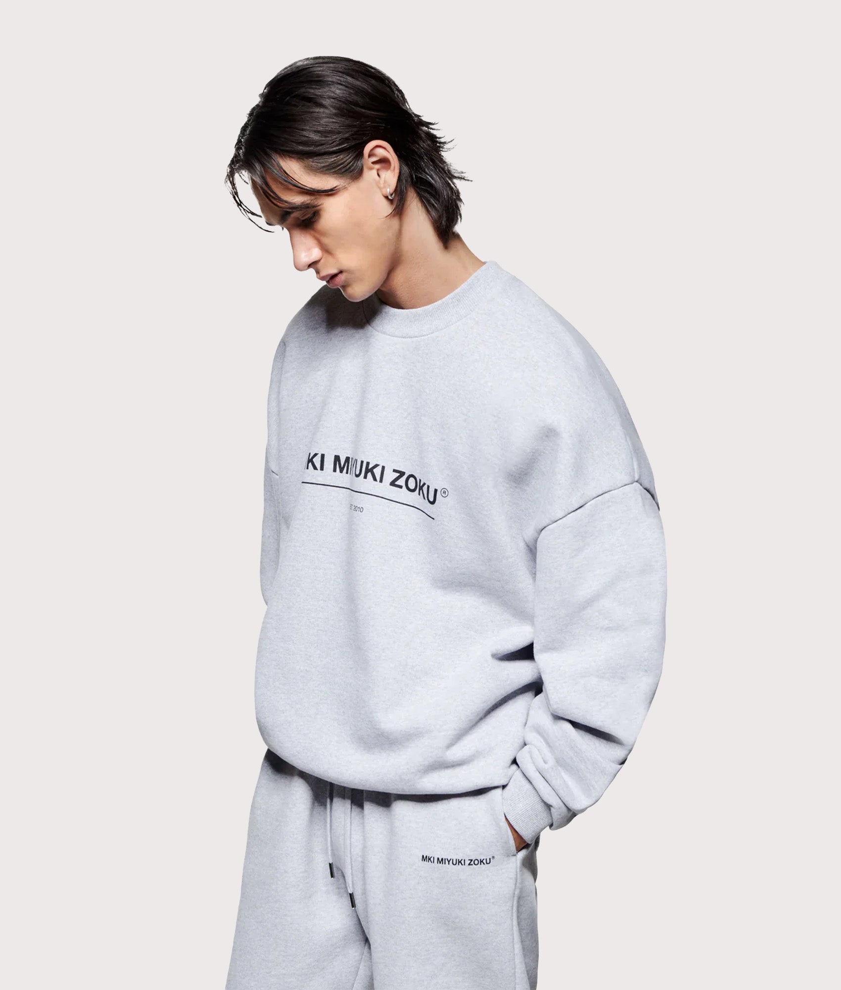 MKI MIYUKI ZOKU Oversized Linear Crewneck Sweatshirt in Grey at EQVVS Menswear. Angled model front shot.